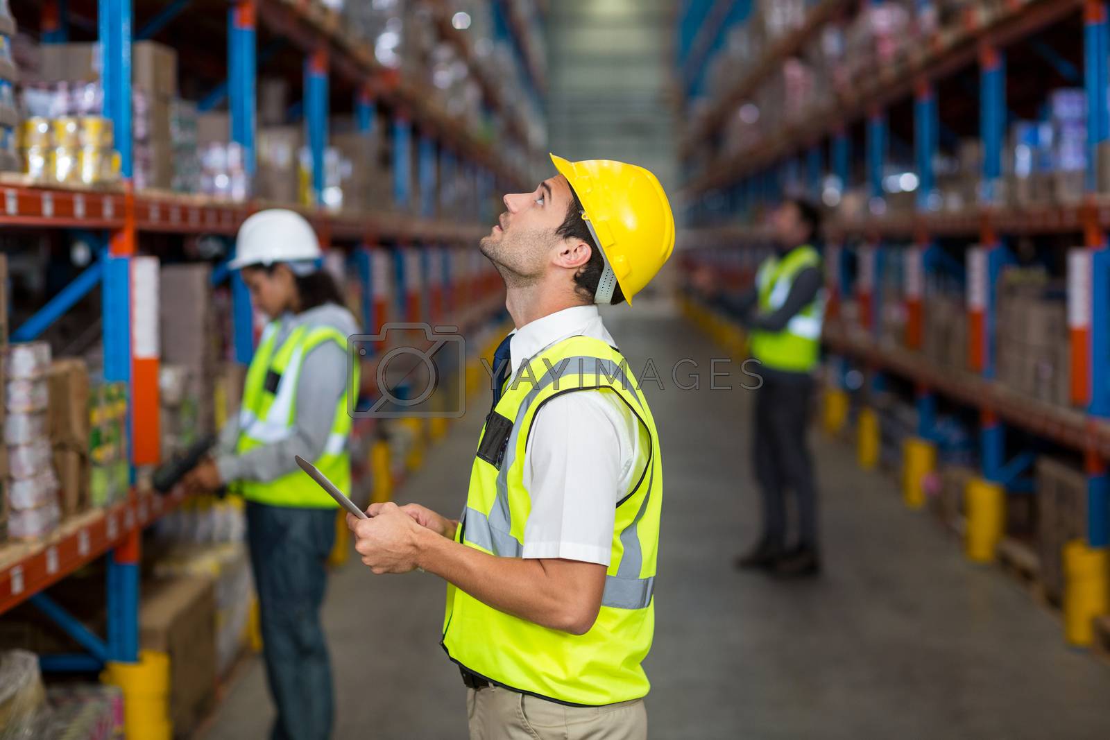 Royalty free image of Worker looking up in warehouse by Wavebreakmedia