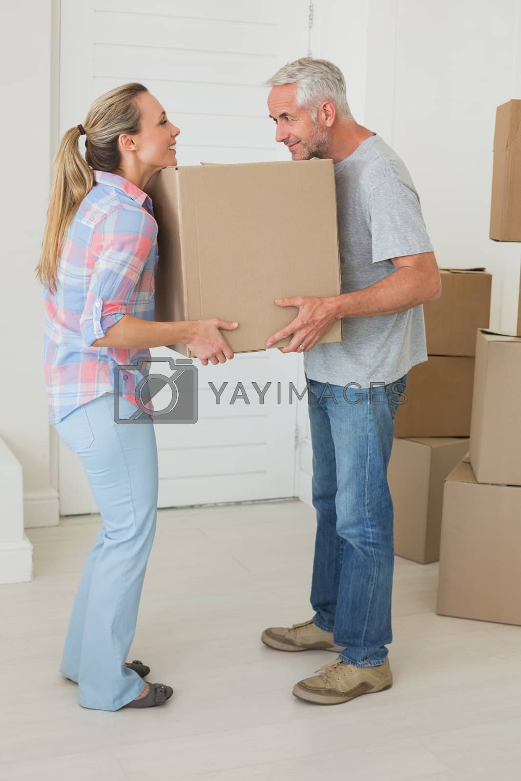 Royalty free image of Happy couple carrying cardboard moving boxes  by Wavebreakmedia