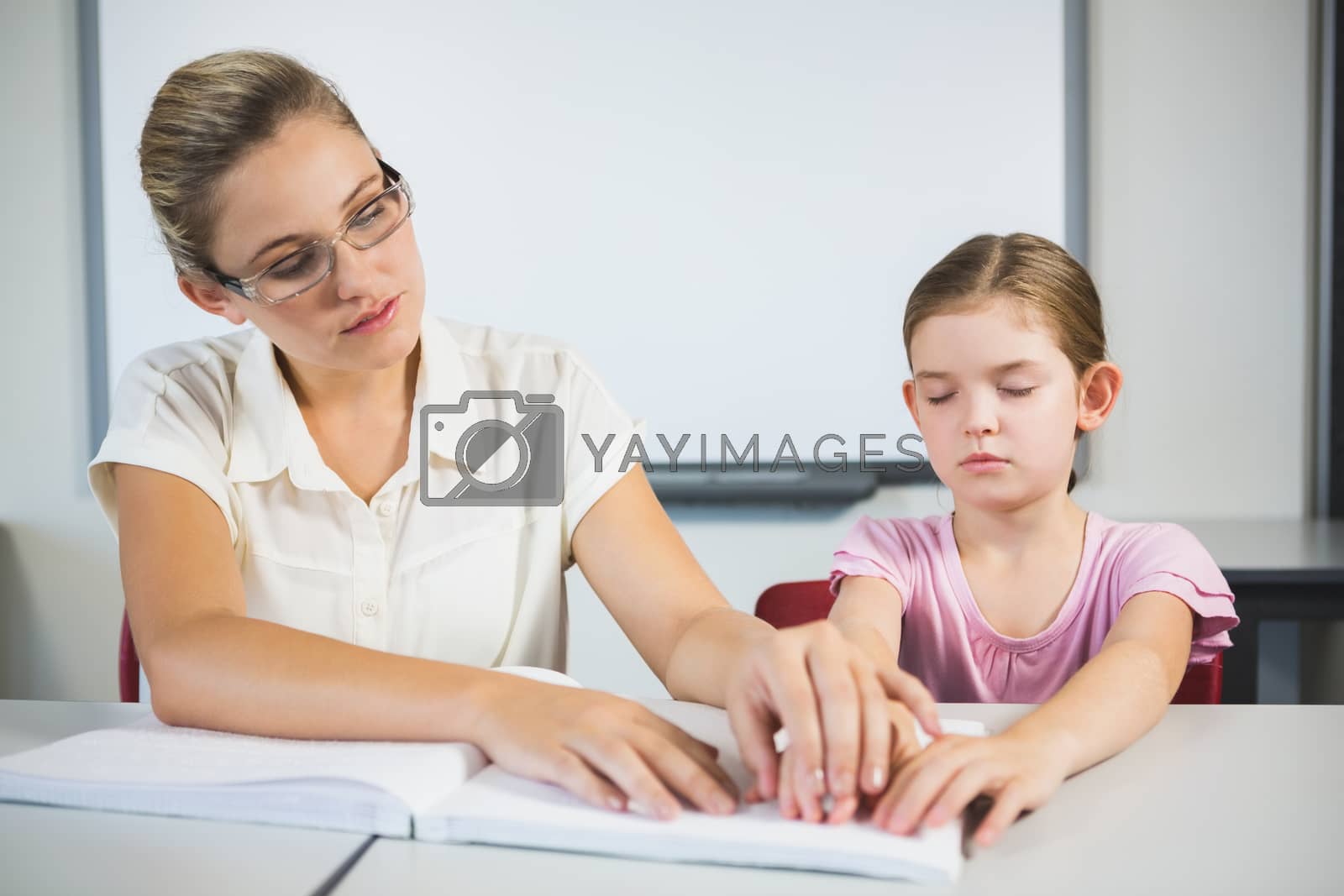 Royalty free image of Teacher assisting blind student in library by Wavebreakmedia