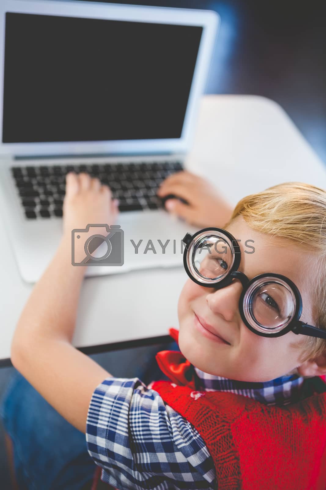Royalty free image of Portrait of schoolkid using laptop in classroom by Wavebreakmedia