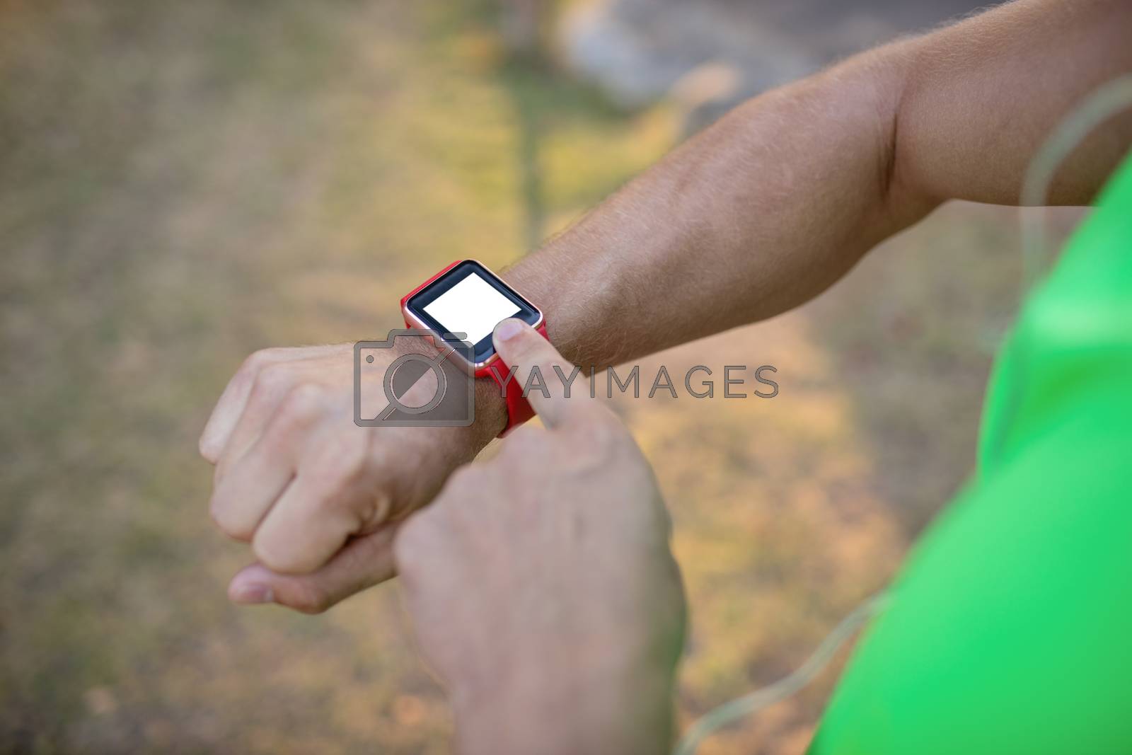 Royalty free image of Jogger setting a smartwatch by Wavebreakmedia