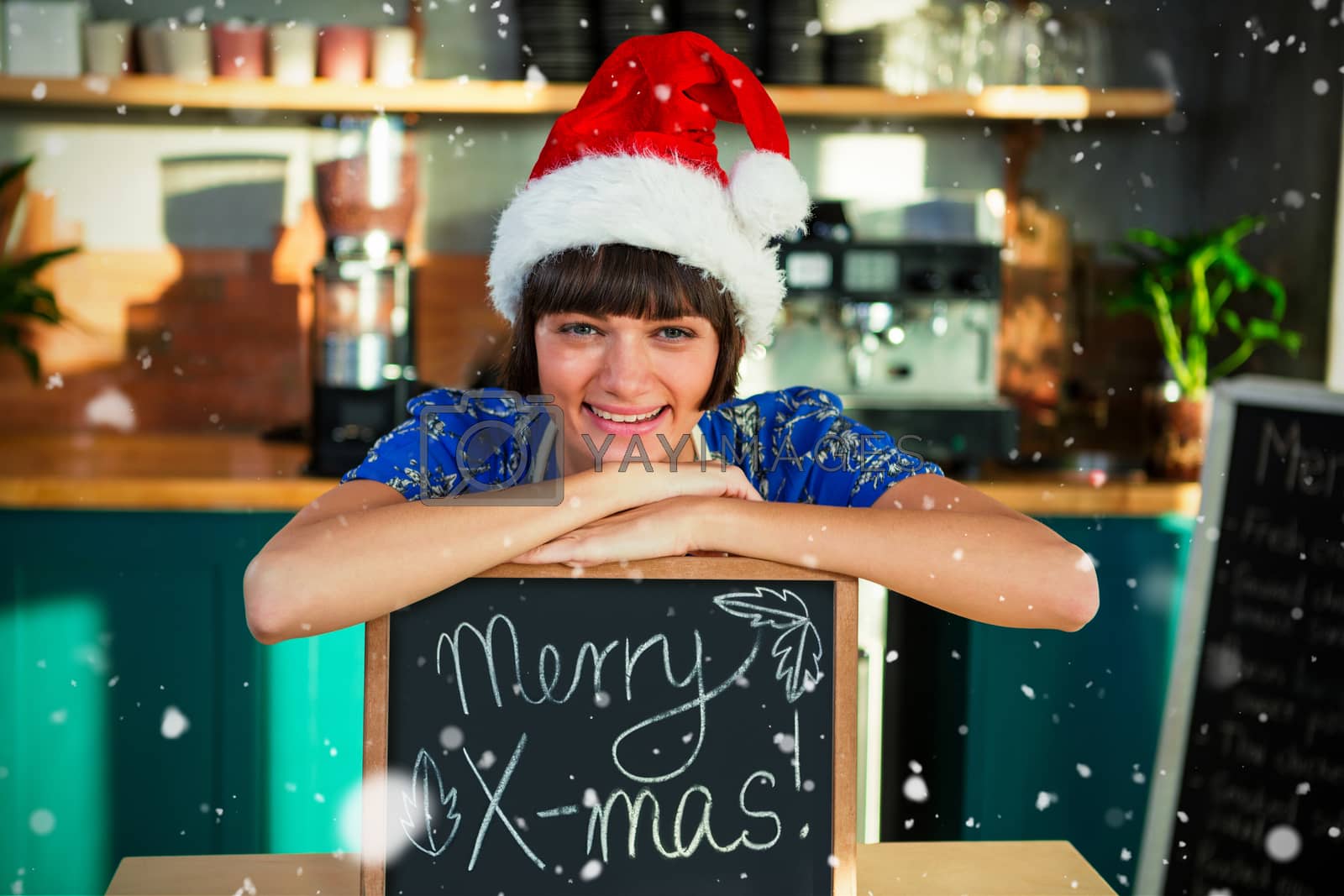 Royalty free image of Composite image of portrait of smiling waitress wearing santa hat and sitting with x-mas sign board by Wavebreakmedia
