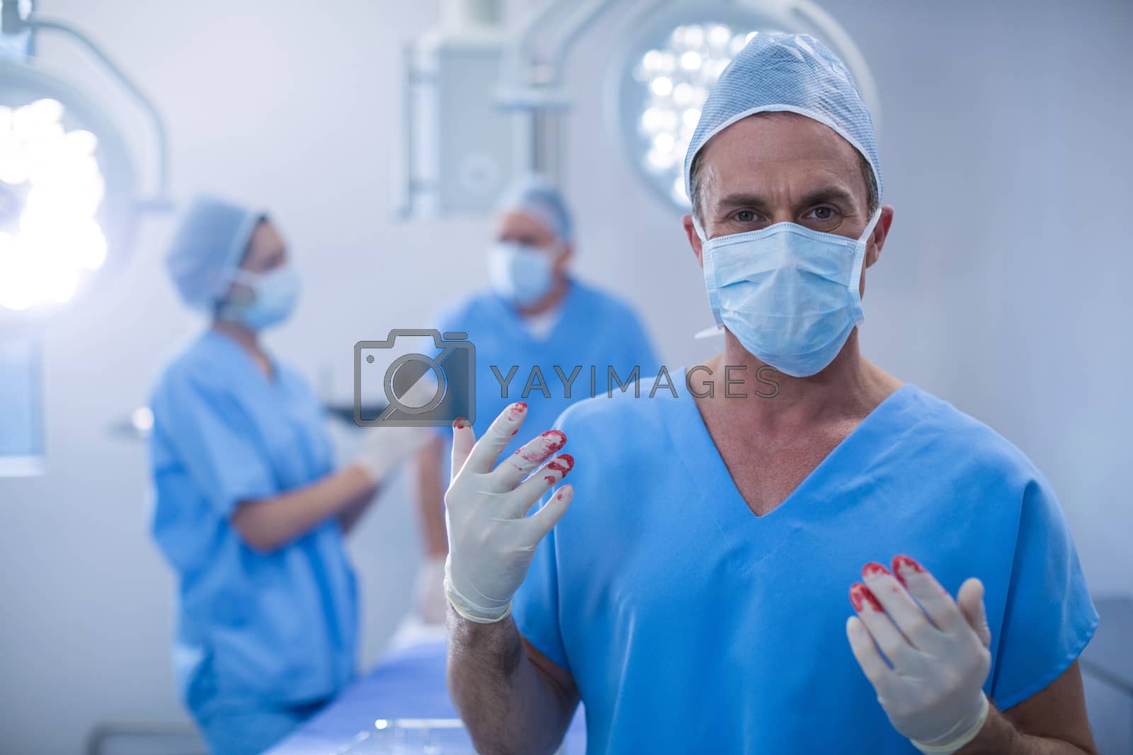 Royalty free image of Portrait of surgeon with blood on surgical glove in operation room by Wavebreakmedia