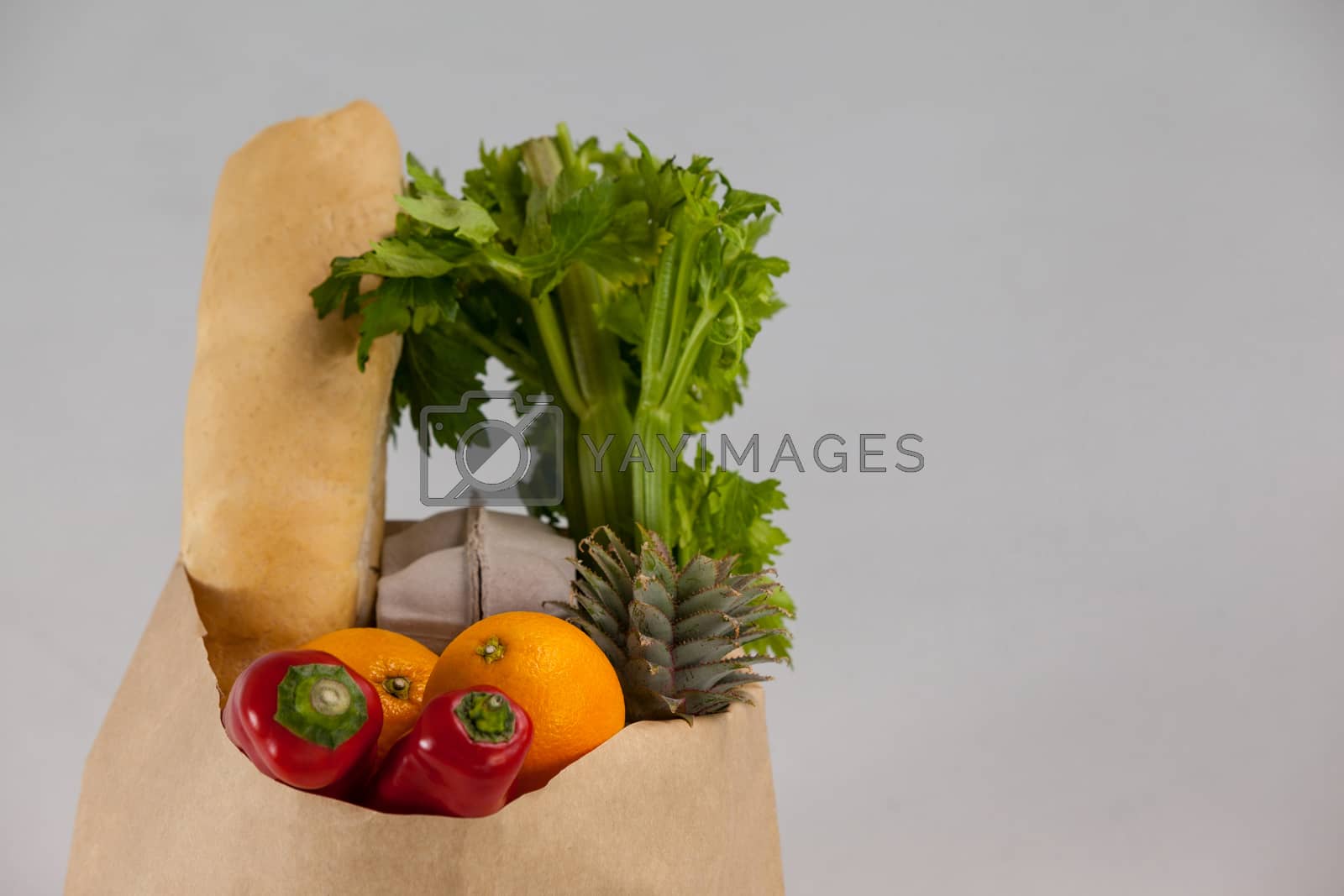 Royalty free image of Fruits and vegetables in brown grocery bag by Wavebreakmedia