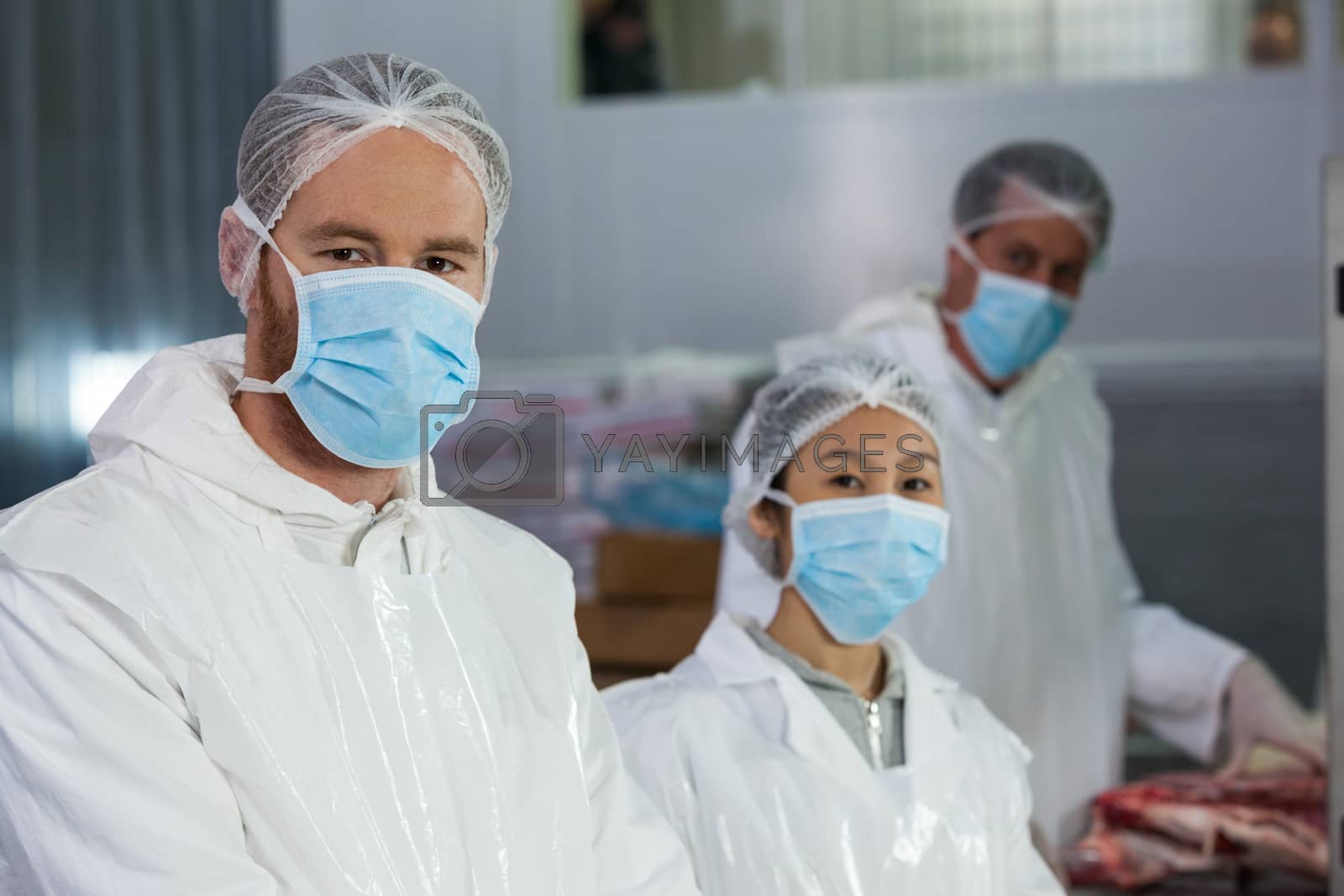 Royalty free image of Butchers in protective workwear at meat factory by Wavebreakmedia