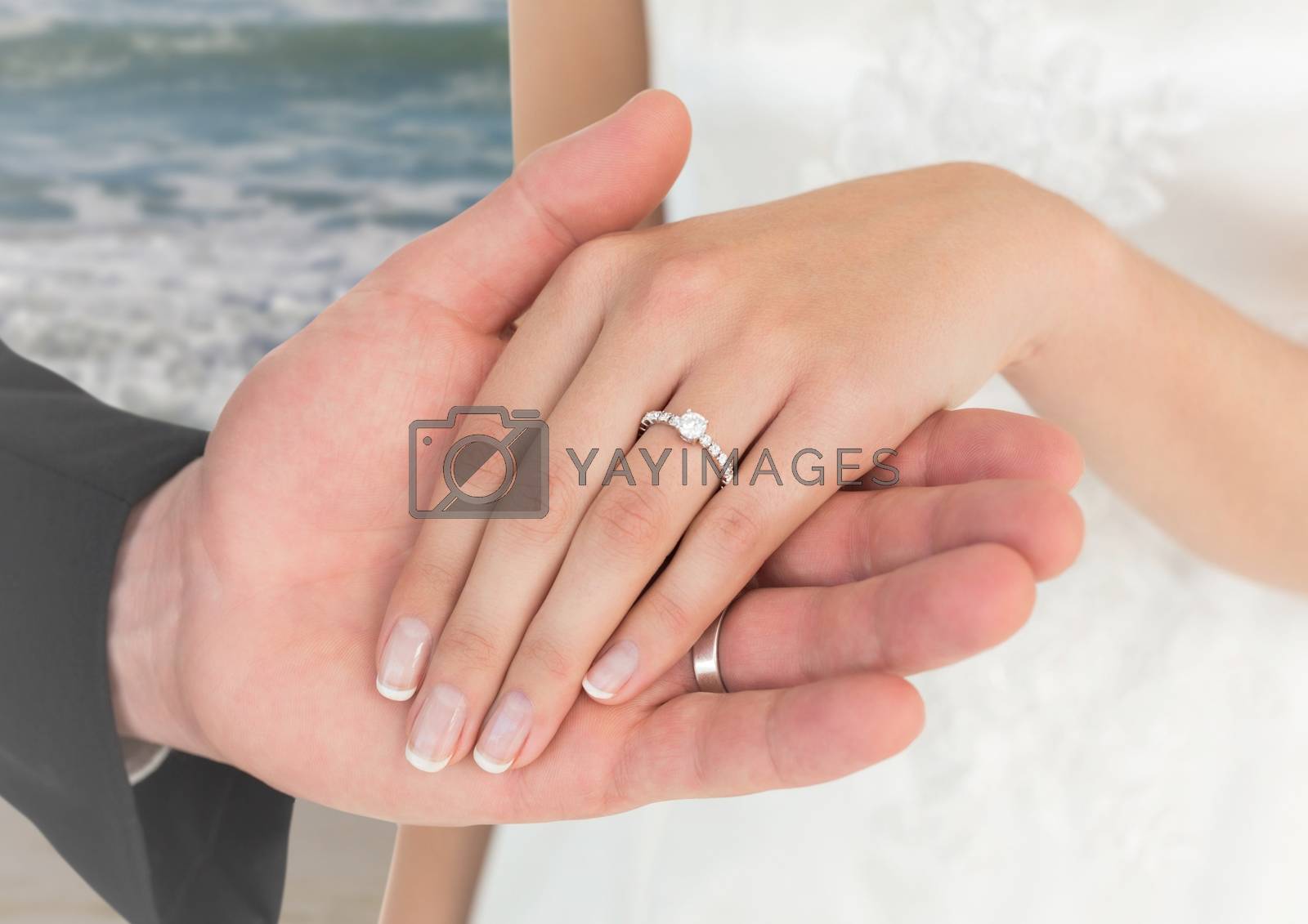 Royalty free image of Newly wed couple holding hands on beach by Wavebreakmedia