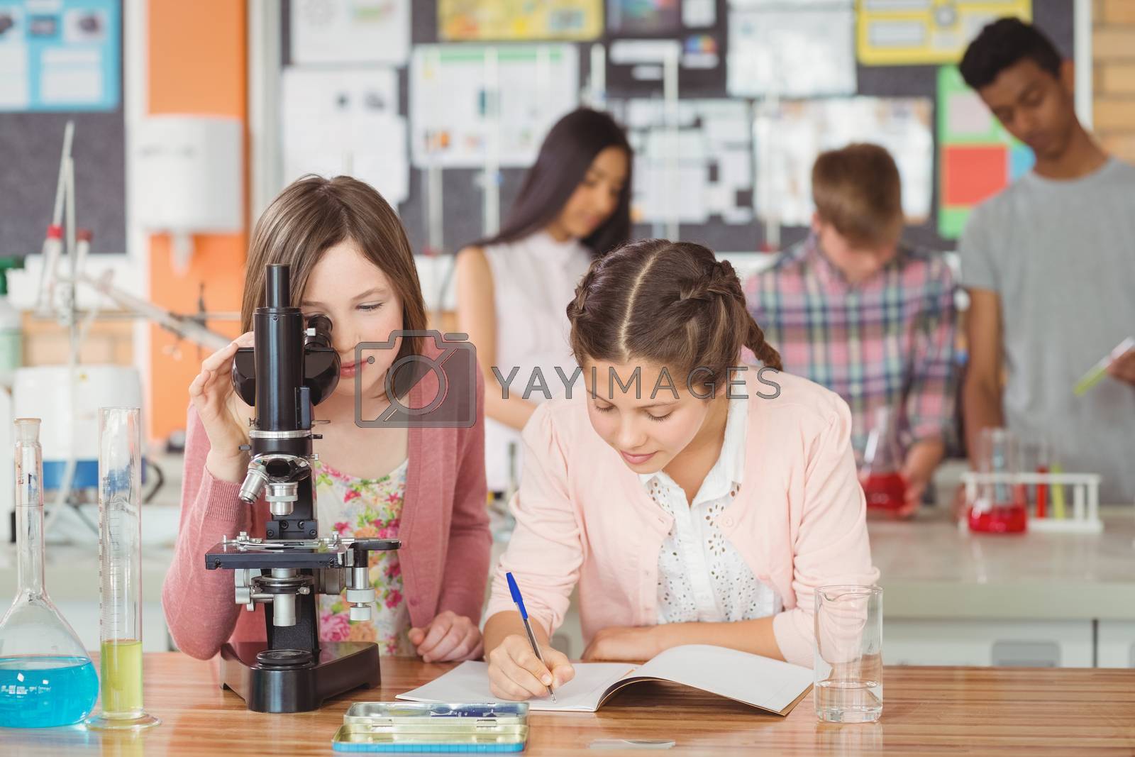 Royalty free image of Students experimenting on microscope in laboratory at school in laboratory by Wavebreakmedia