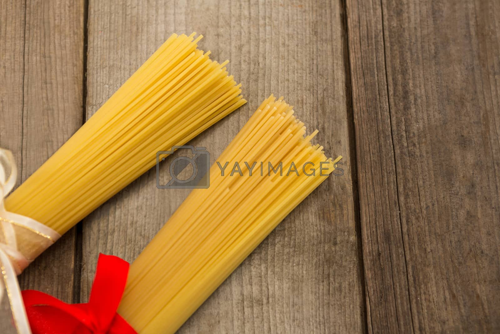 Royalty free image of Bundles of raw spaghetti tied with ribbons by Wavebreakmedia