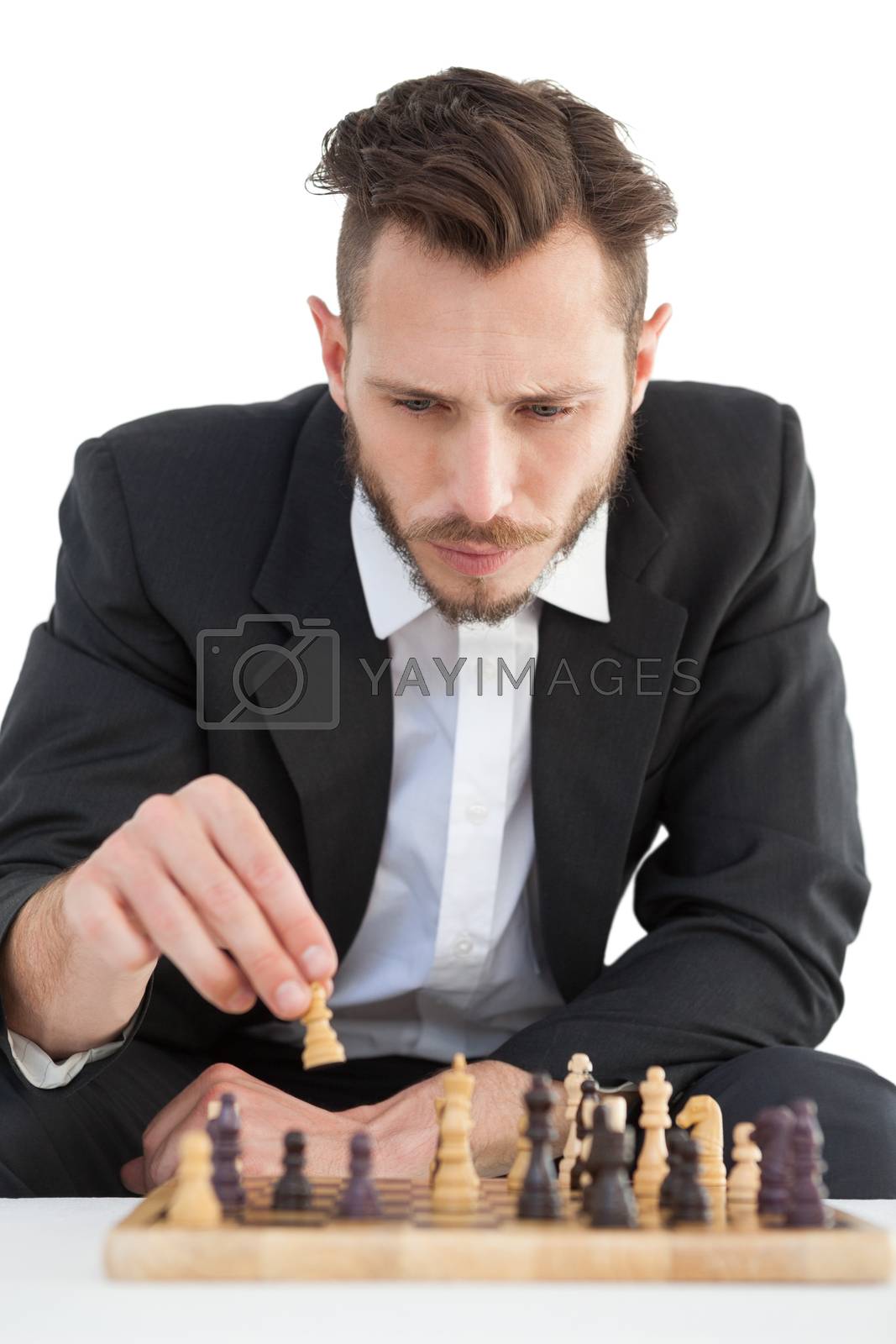 Royalty free image of Focused businessman playing chess solo by Wavebreakmedia