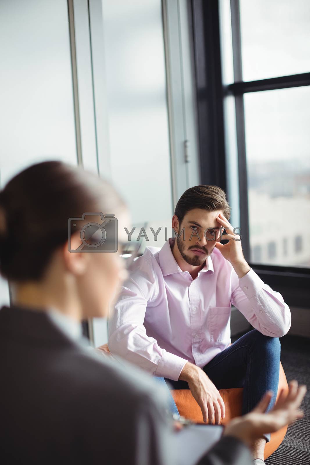 Royalty free image of Unhappy man consulting counselor by Wavebreakmedia
