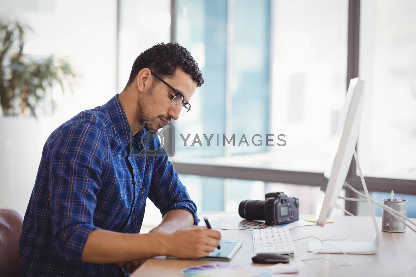 Royalty free image of Graphic designer using graphic tablet at desk by Wavebreakmedia