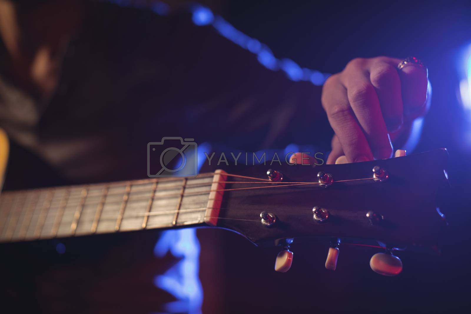 Royalty free image of Mid section of musician adjusting tuning peg by Wavebreakmedia