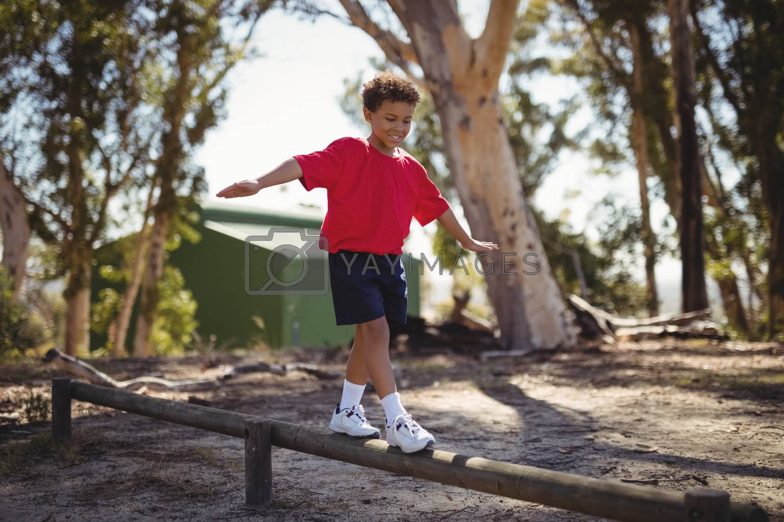Royalty free image of Happy boy exercising on obstacle during obstacle course by Wavebreakmedia