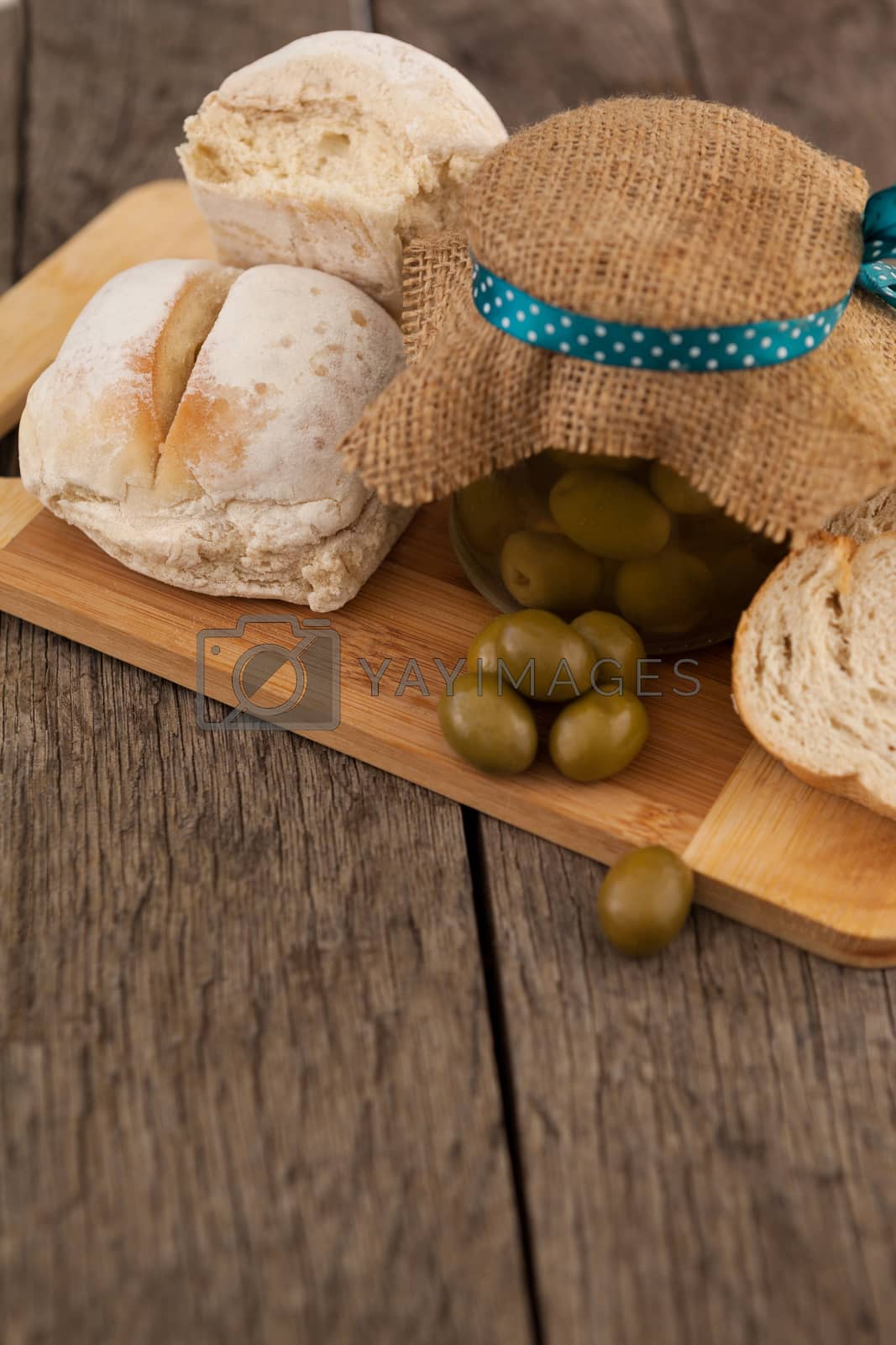 Royalty free image of Olives in jar wrapped with jute by bread by Wavebreakmedia