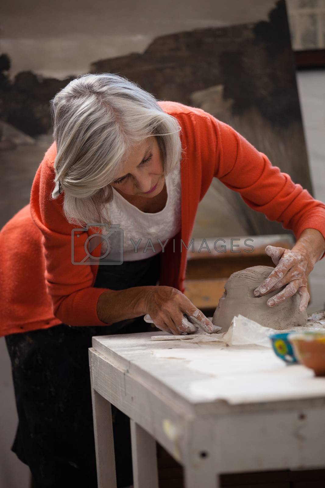 Royalty free image of Attentive senior woman shaping a molded clay by Wavebreakmedia