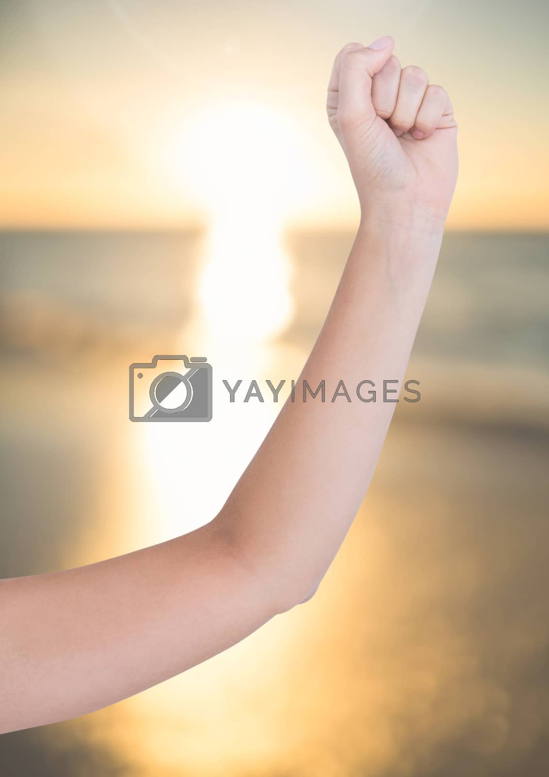 Royalty free image of Arm posing in front of tranquil sea sunset by Wavebreakmedia