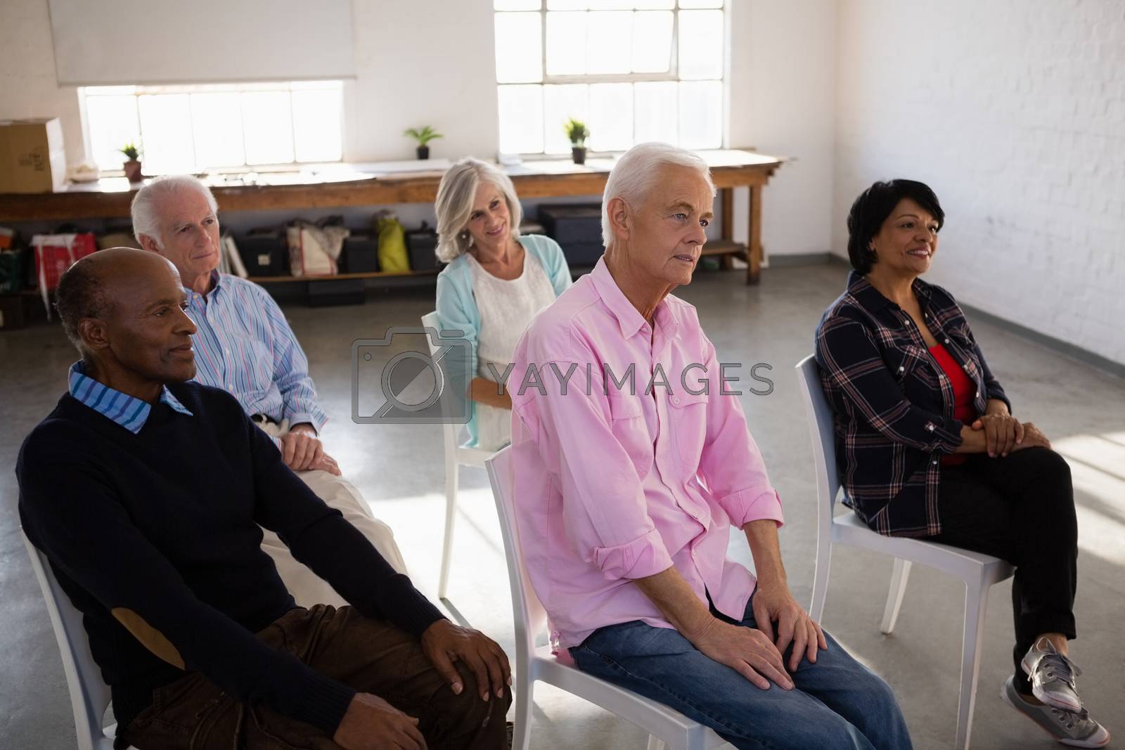 Royalty free image of Attentive senior people sitting on chair by Wavebreakmedia