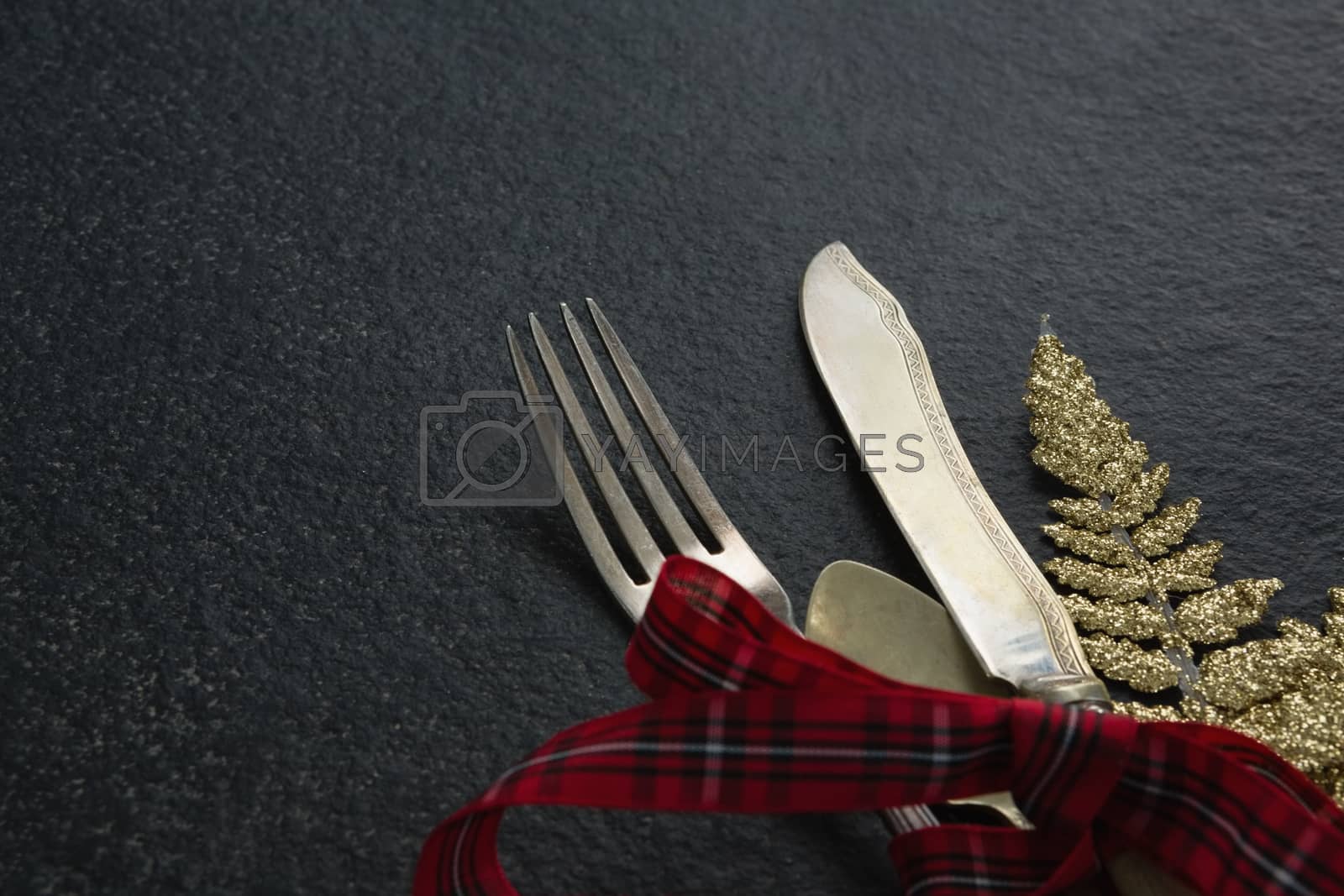 Royalty free image of Cutlery with christmas ornament tied up with ribbon by Wavebreakmedia