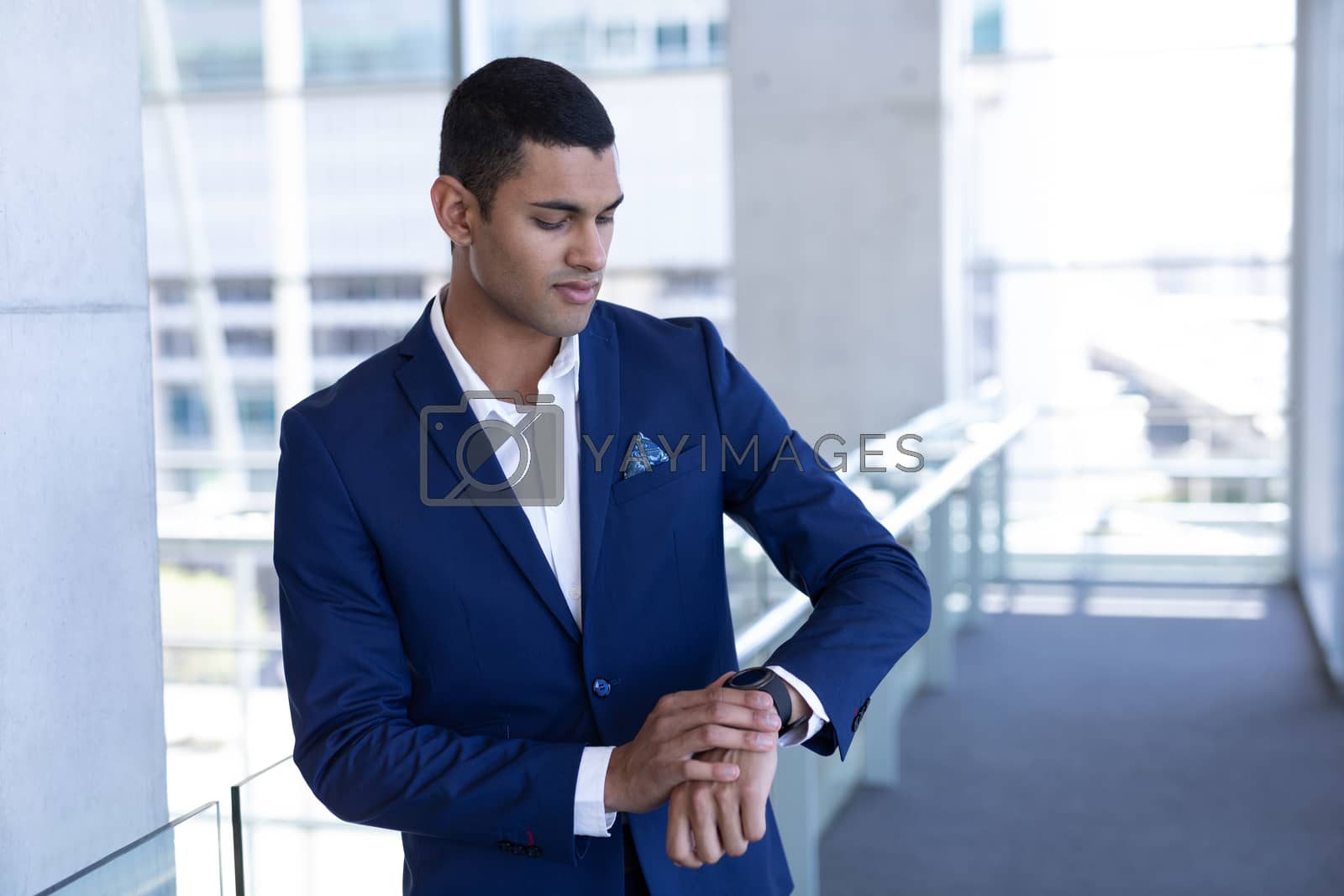 Royalty free image of Young mixed-race businessman using smartwatch in modern office by Wavebreakmedia