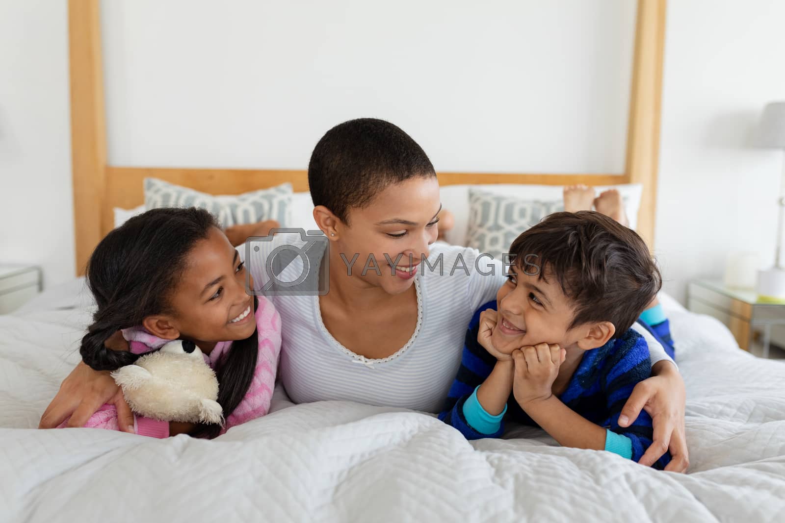 Royalty free image of Mother and children relaxing together on bed in bedroom by Wavebreakmedia