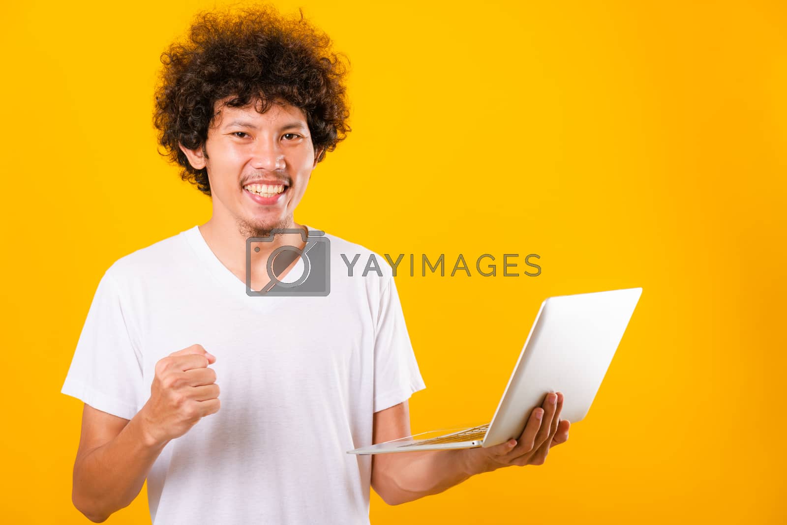 Royalty free image of Asian handsome man with curly hair using laptop computer isolate by Sorapop