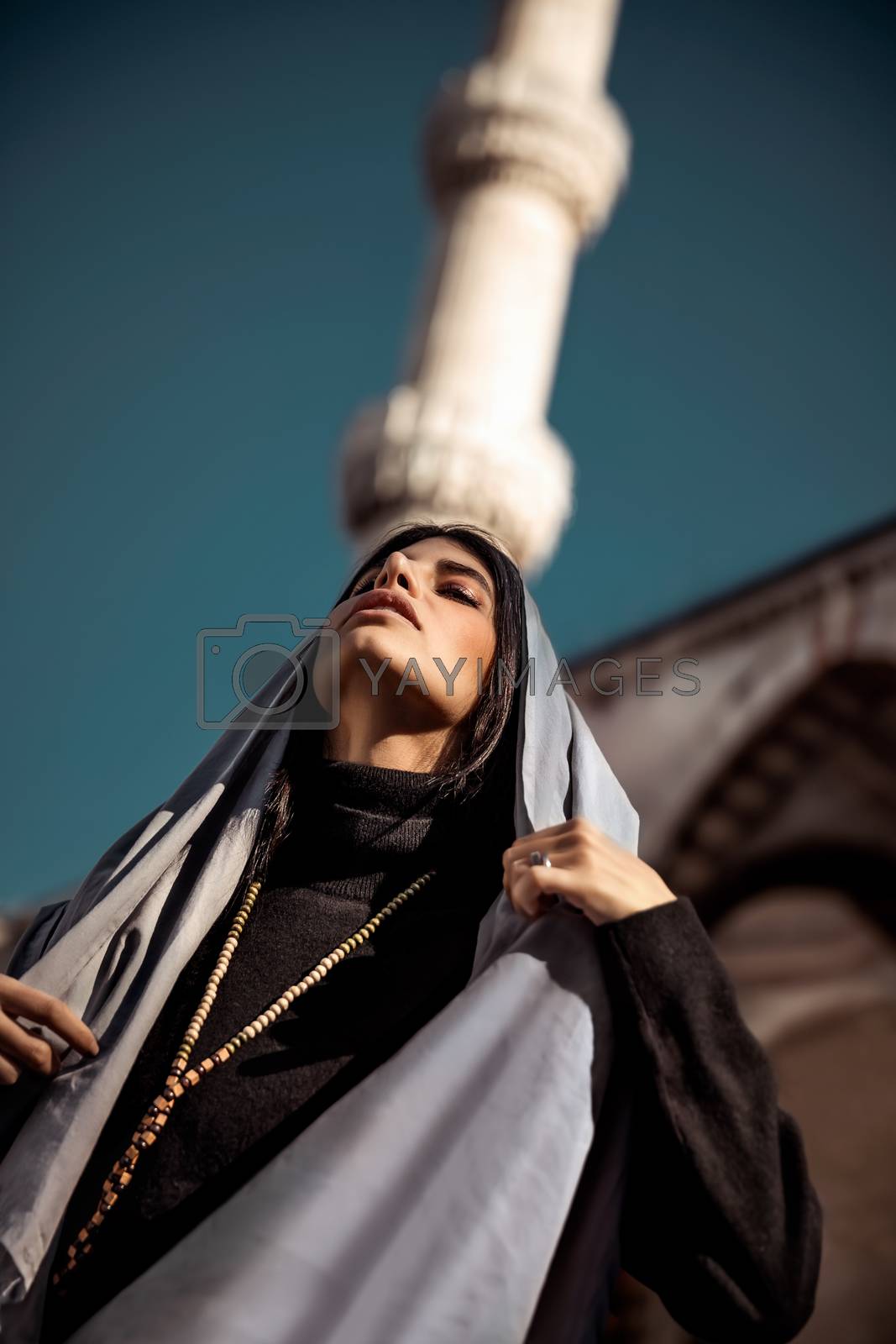 Portrait of a stunning arabic model posing near the mosque, wearing traditional islamic scarf, Muslim style outfit, gorgeous attractive woman, arabian fashion
