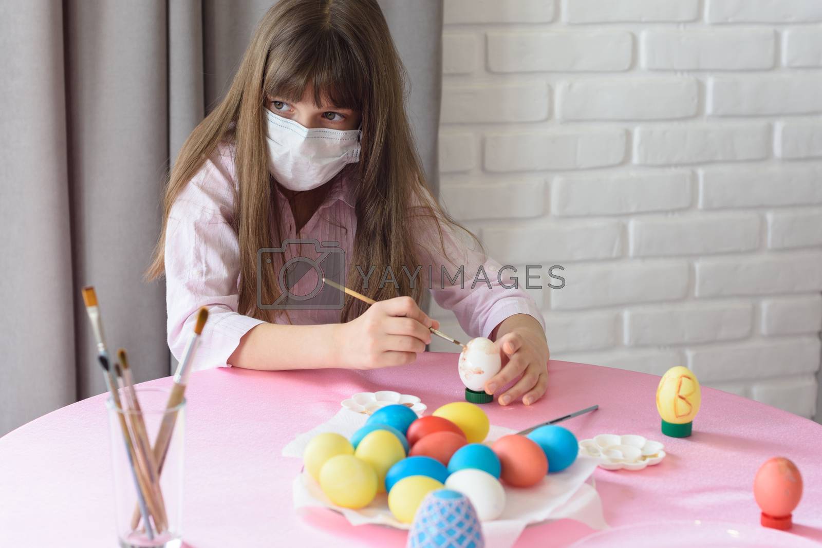 Royalty free image of Sad sick quarantined girl paints Easter eggs by Madhourse