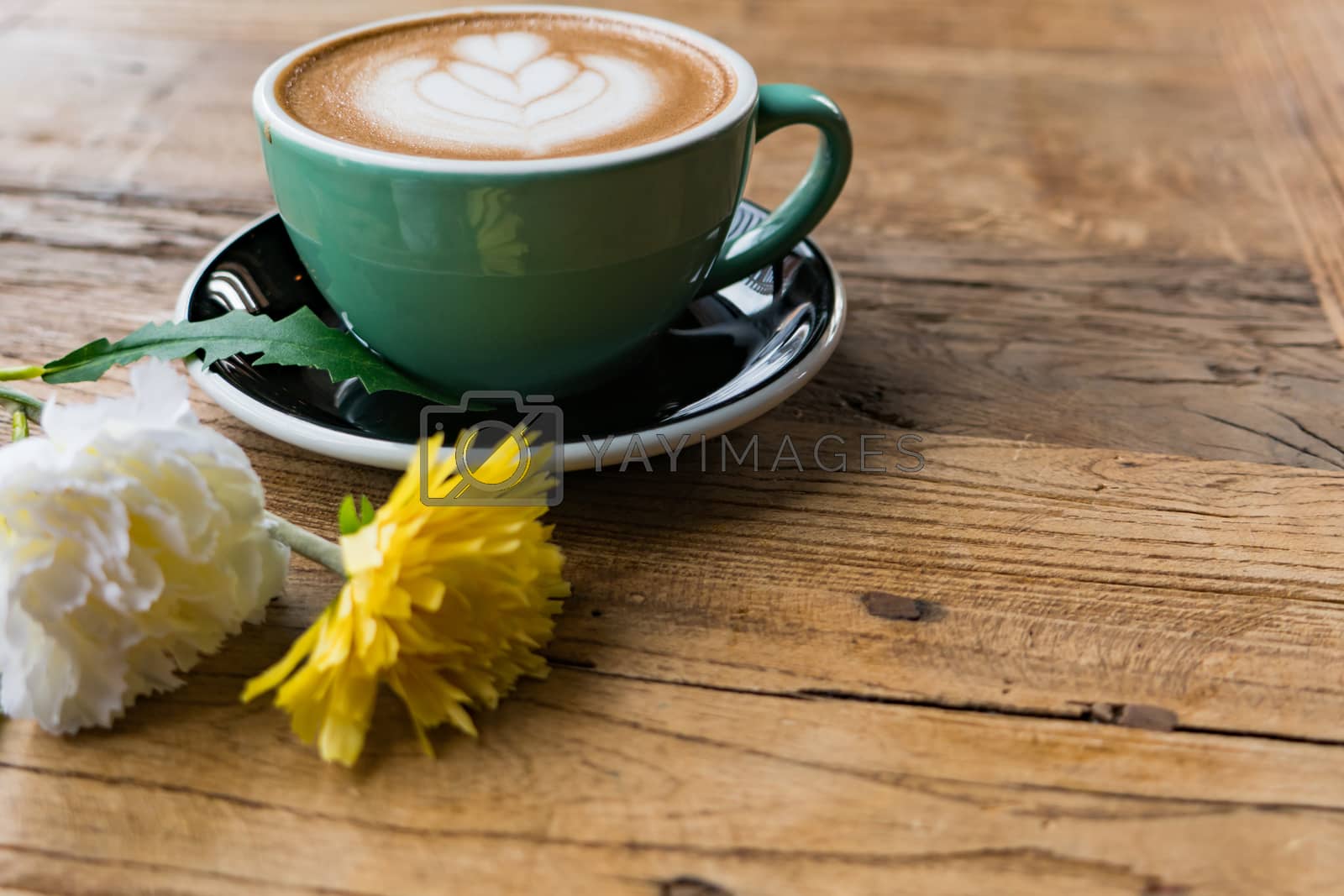 Royalty free image of Hot mocha coffee or capuchino with heart pattern and yellow flow by psodaz