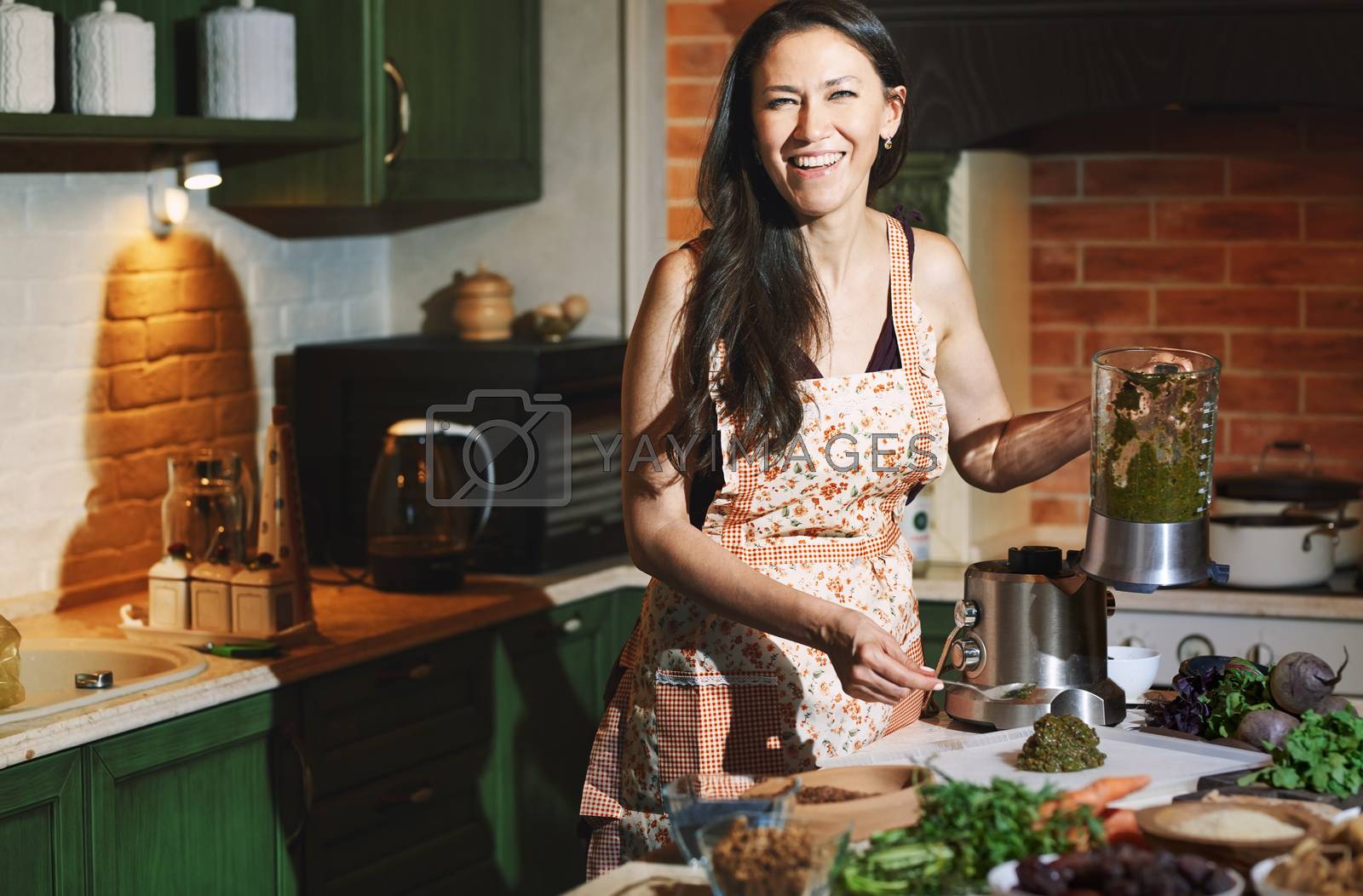 Royalty free image of Staying at home woman using mixer for to prepare vegetarian food by Novic