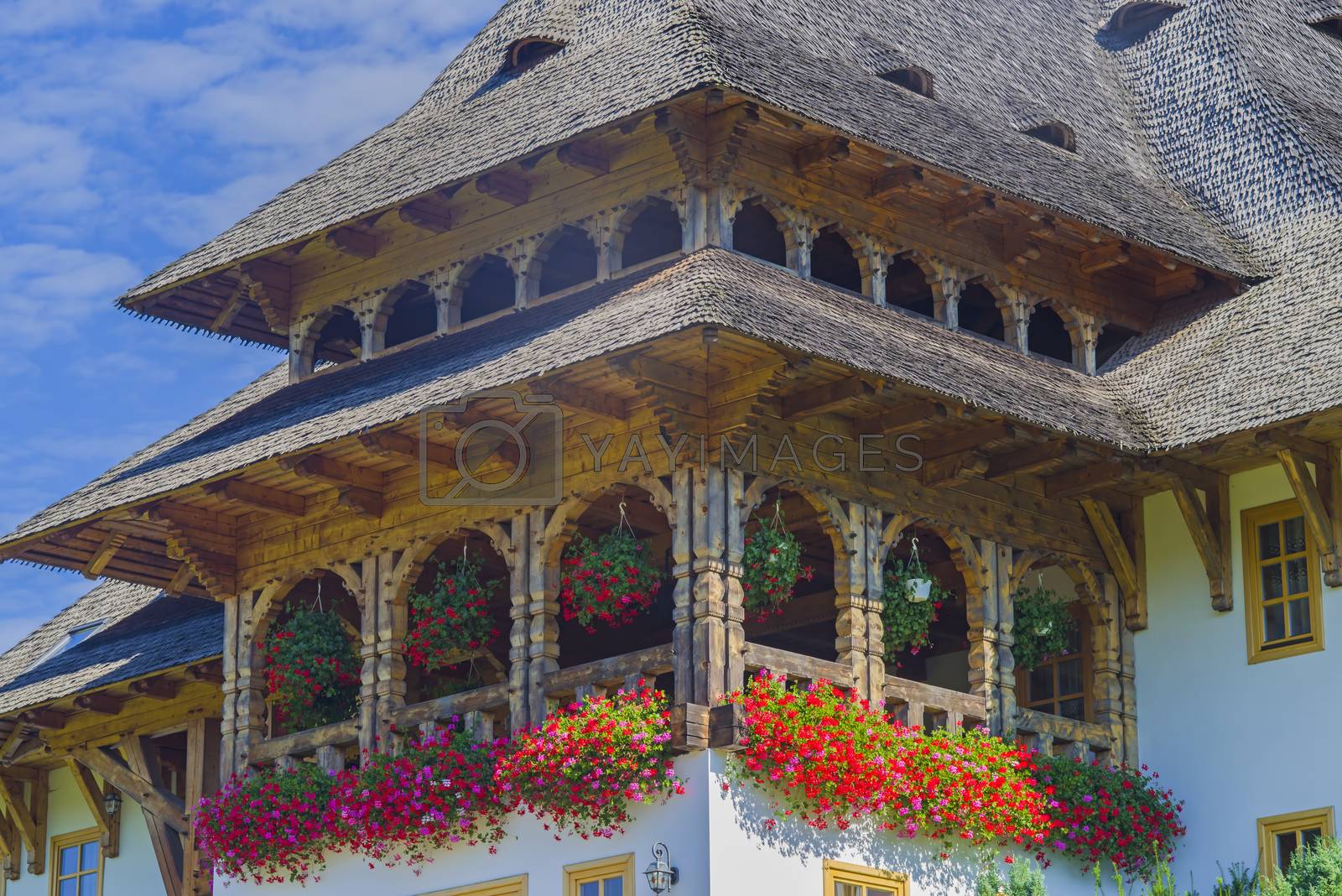 Orthodox Monastery of Barsana in Maramures, Romania; summer flower scene at house entrance