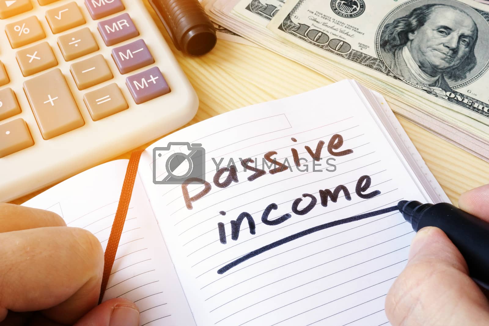 Royalty free image of Passive income written in a note. by designer491