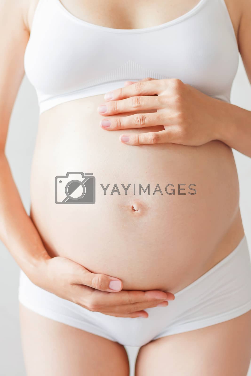 Royalty free image of Pregnant woman in white underwear. Young woman expecting a baby. by aksenovko