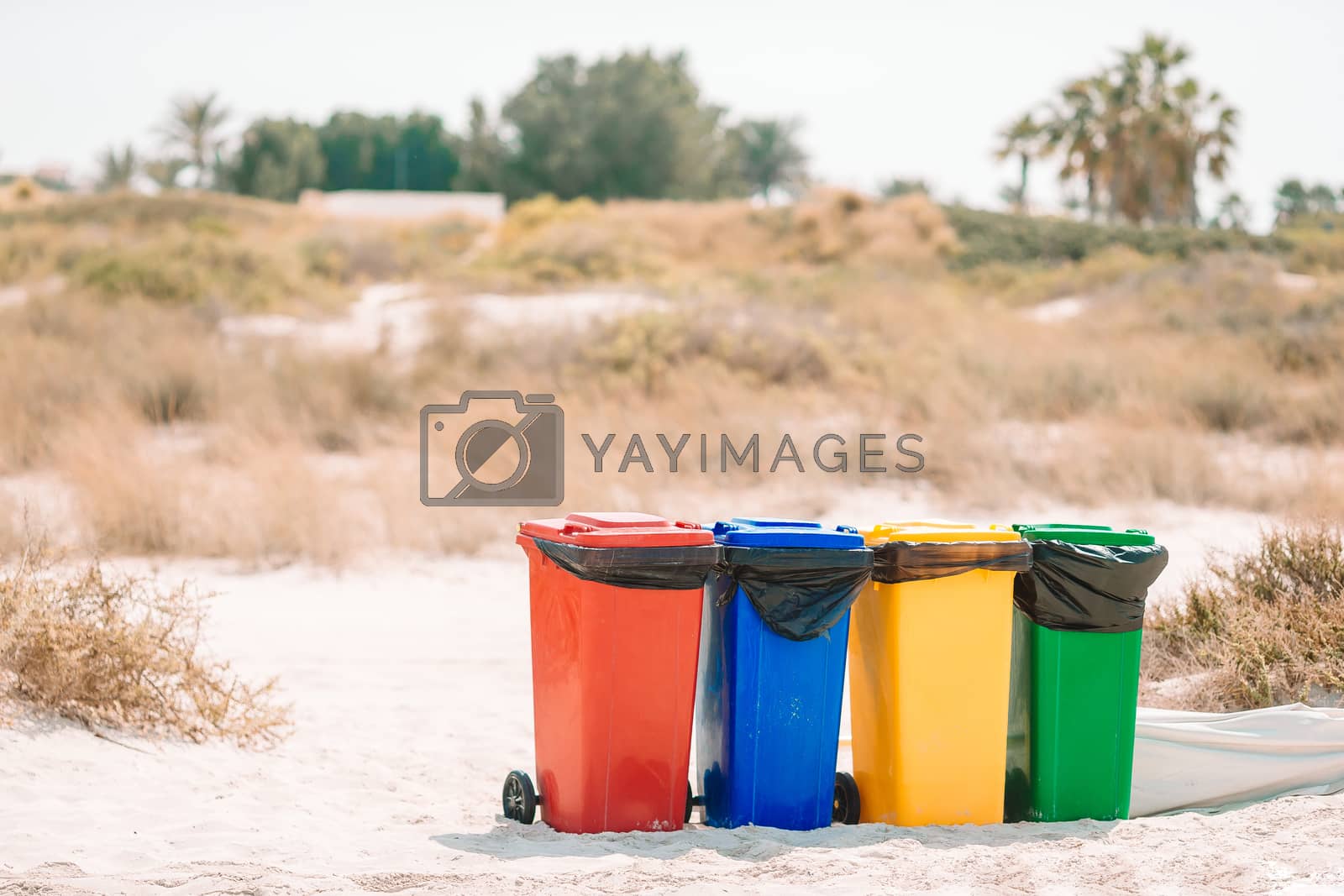 Royalty free image of Four plastic containers for garbage sorting on the beach. by travnikovstudio