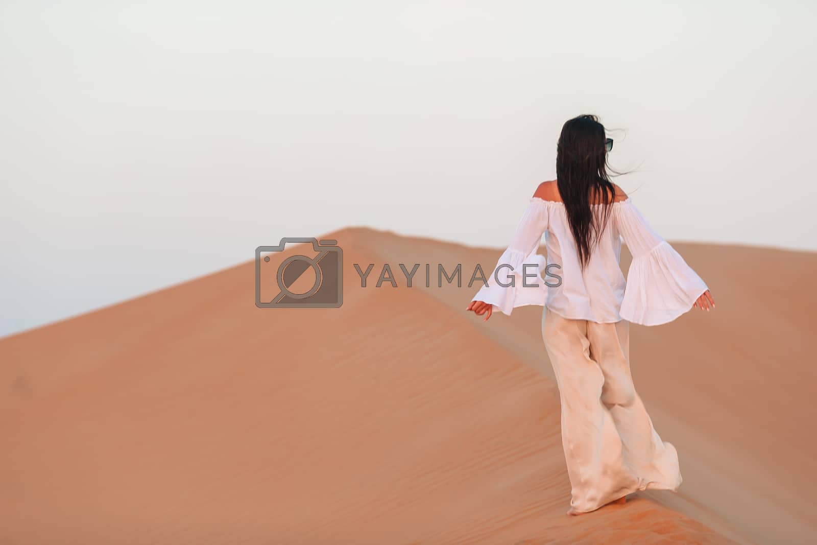 Royalty free image of Girl among dunes in desert in United Arab Emirates by travnikovstudio