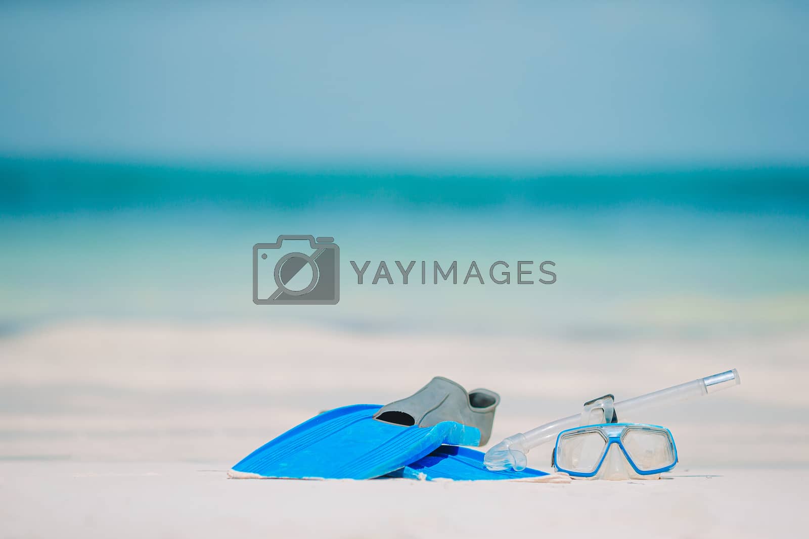 Royalty free image of Snorkeling equipment mask, snorkel and fins on white beach by travnikovstudio