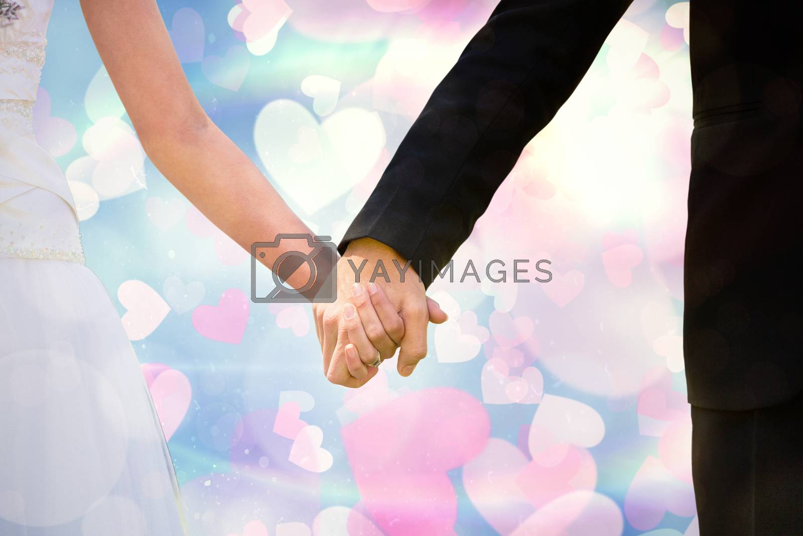 Royalty free image of Composite image of mid section of newlywed couple holding hands in park by Wavebreakmedia