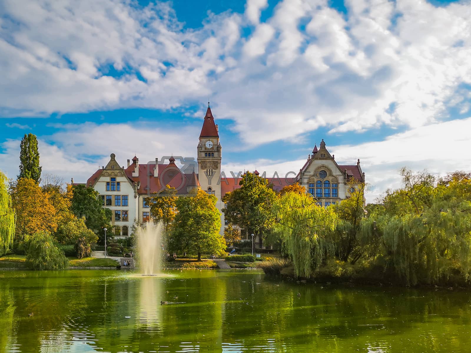 Royalty free image of Lake in center of Wroclaw Tolpa Park with fountain in center with faculty of architecture of Wroclaw University by Wierzchu