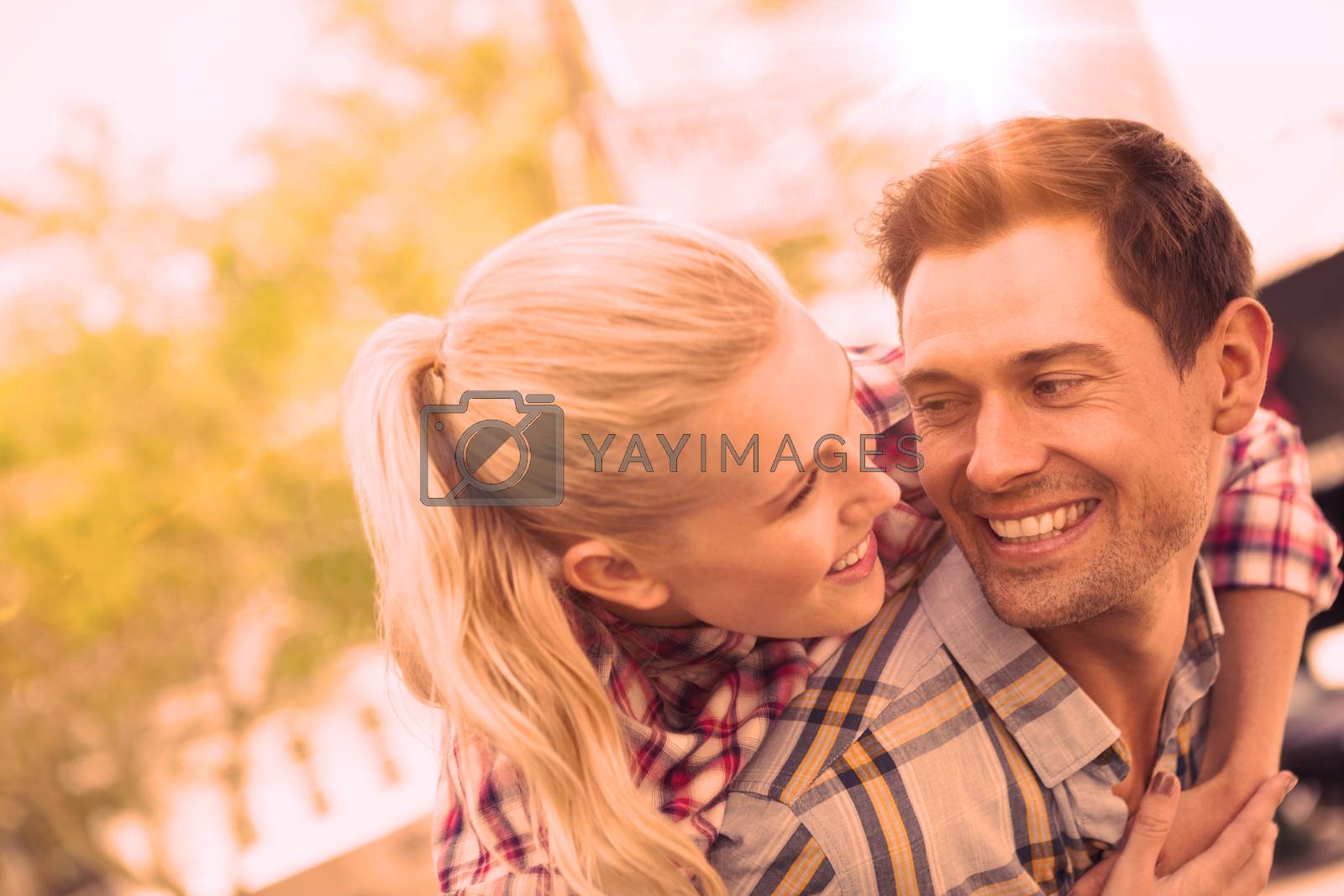 Royalty free image of Man giving his pretty girlfriend a piggy back by Wavebreakmedia