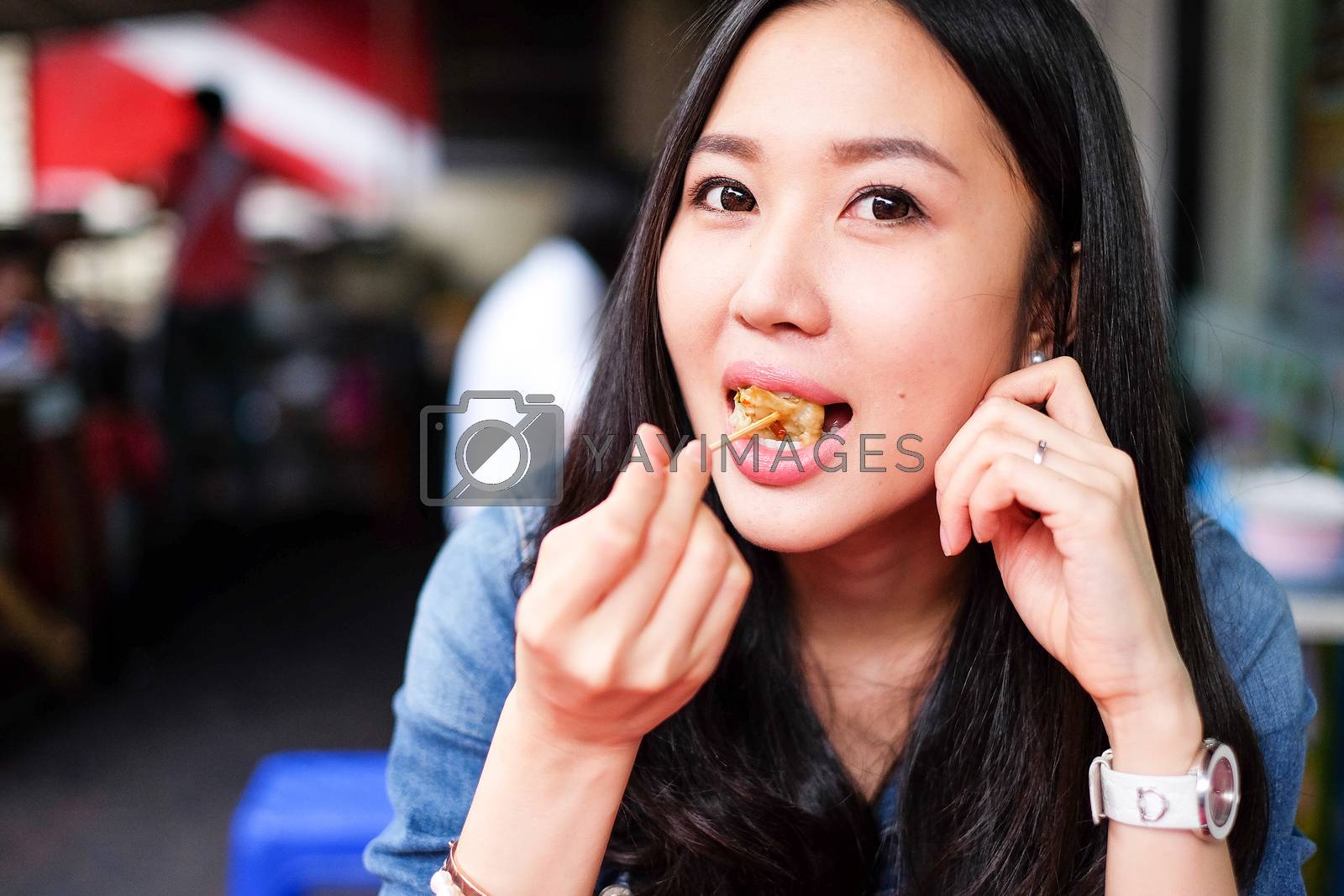 Royalty free image of Woman eating Chinese Shanghainese steamed dumpling buns  by Surasak