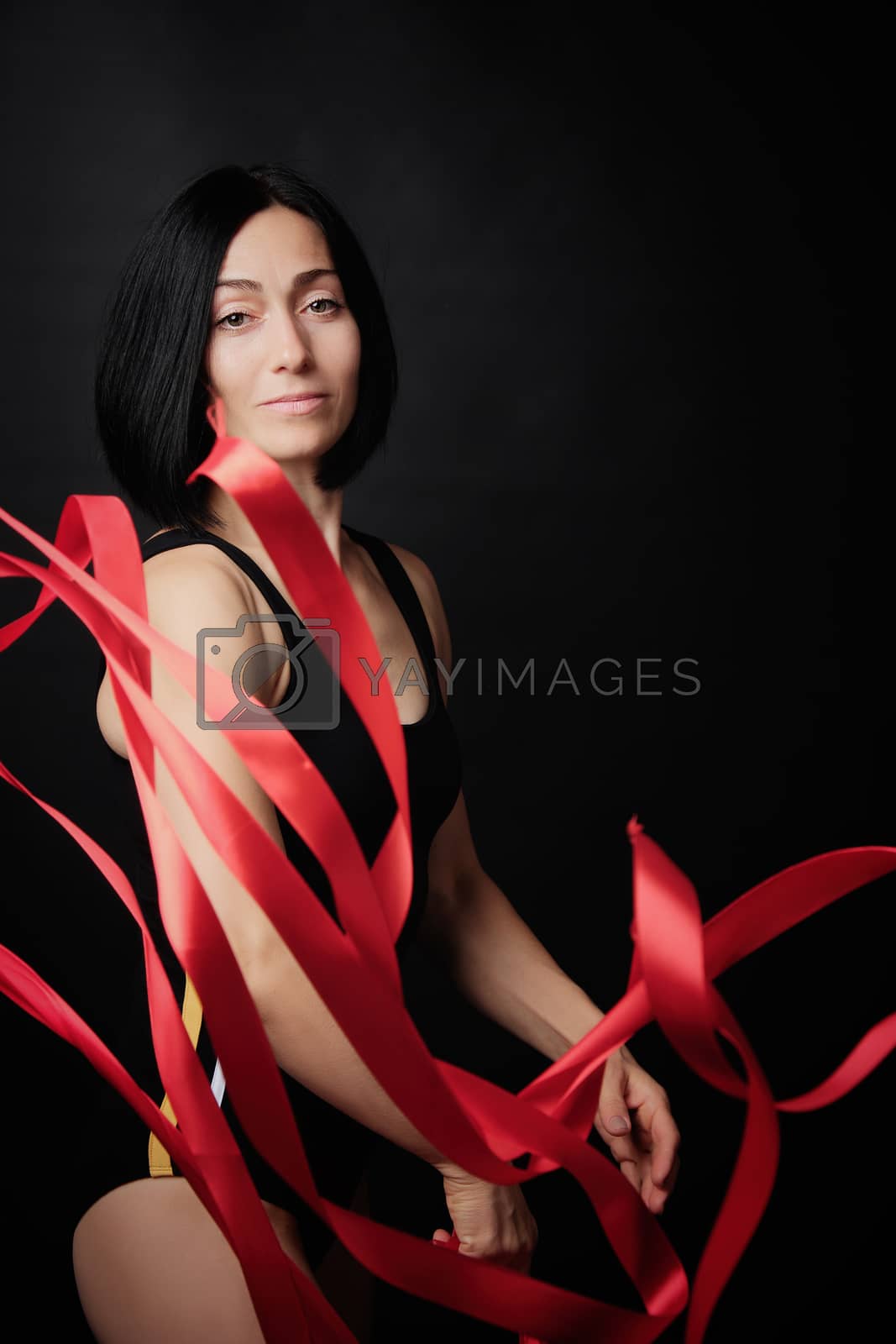 Royalty free image of young woman gymnast of Caucasian appearance with black hair spin by ndanko