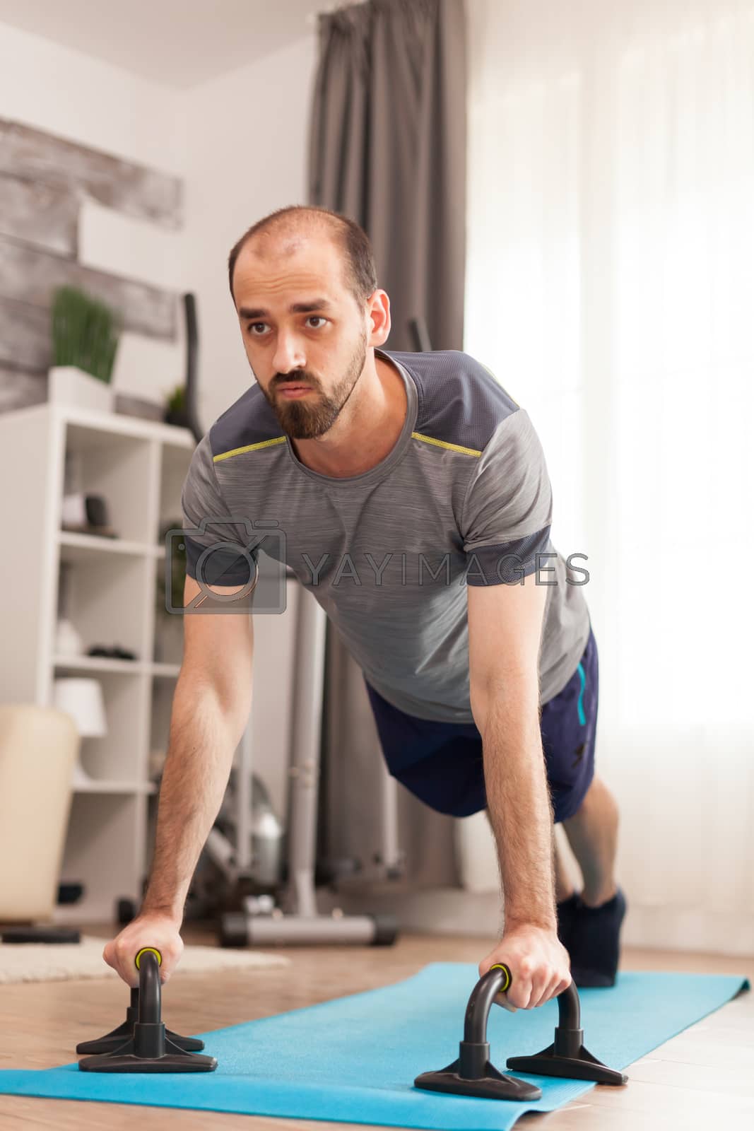 Royalty free image of Man in good physical shape doing push ups by DCStudio