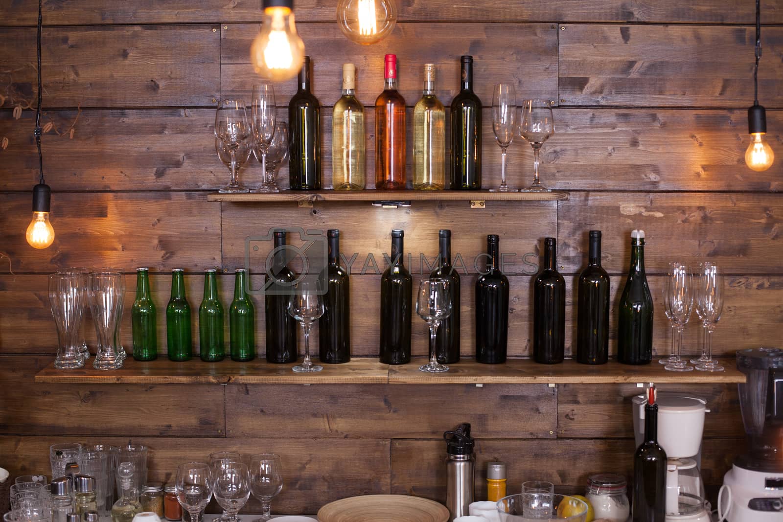 Royalty free image of Shelves in a pub full of different wine bottles by DCStudio