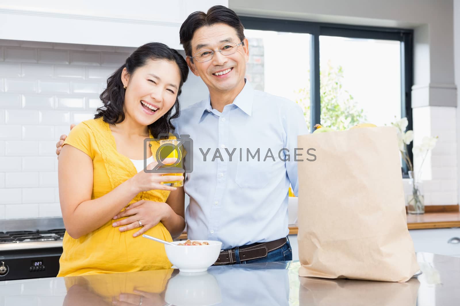 Royalty free image of Portrait of happy expectant couple by Wavebreakmedia