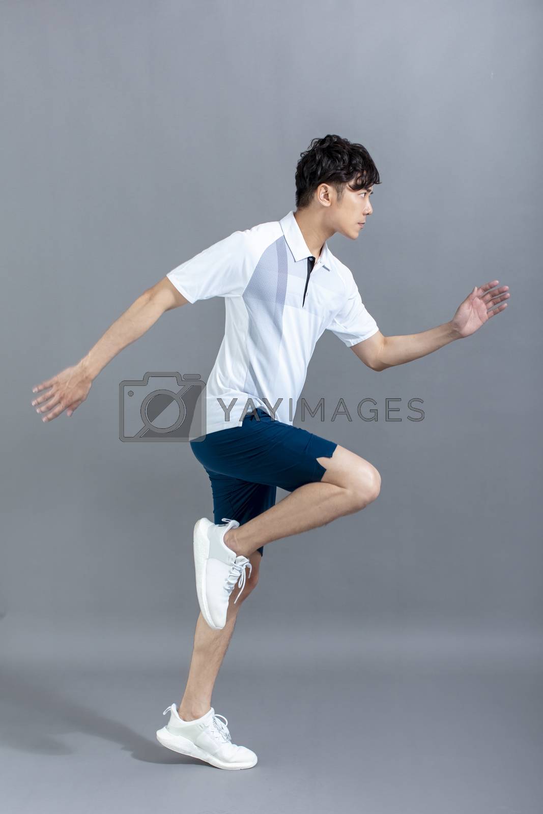Royalty free image of  portrait of  fitness young man running on the gray background by tomwang