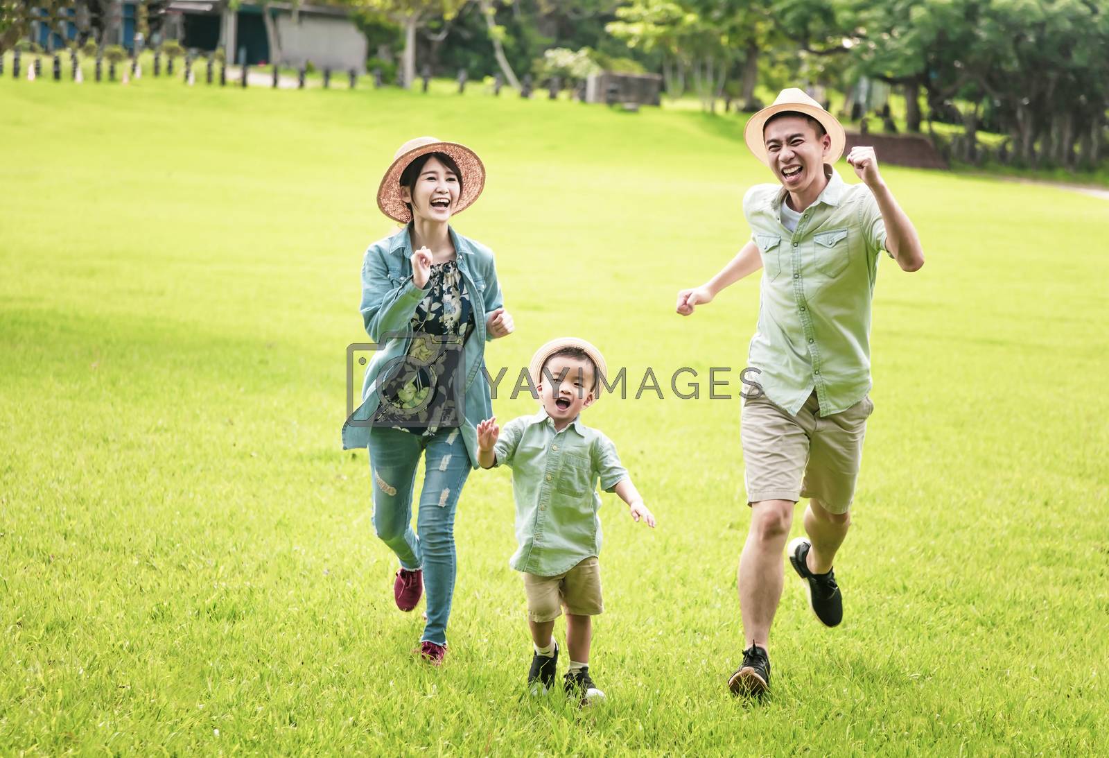 Royalty free image of Happy family  running together on the grass by tomwang