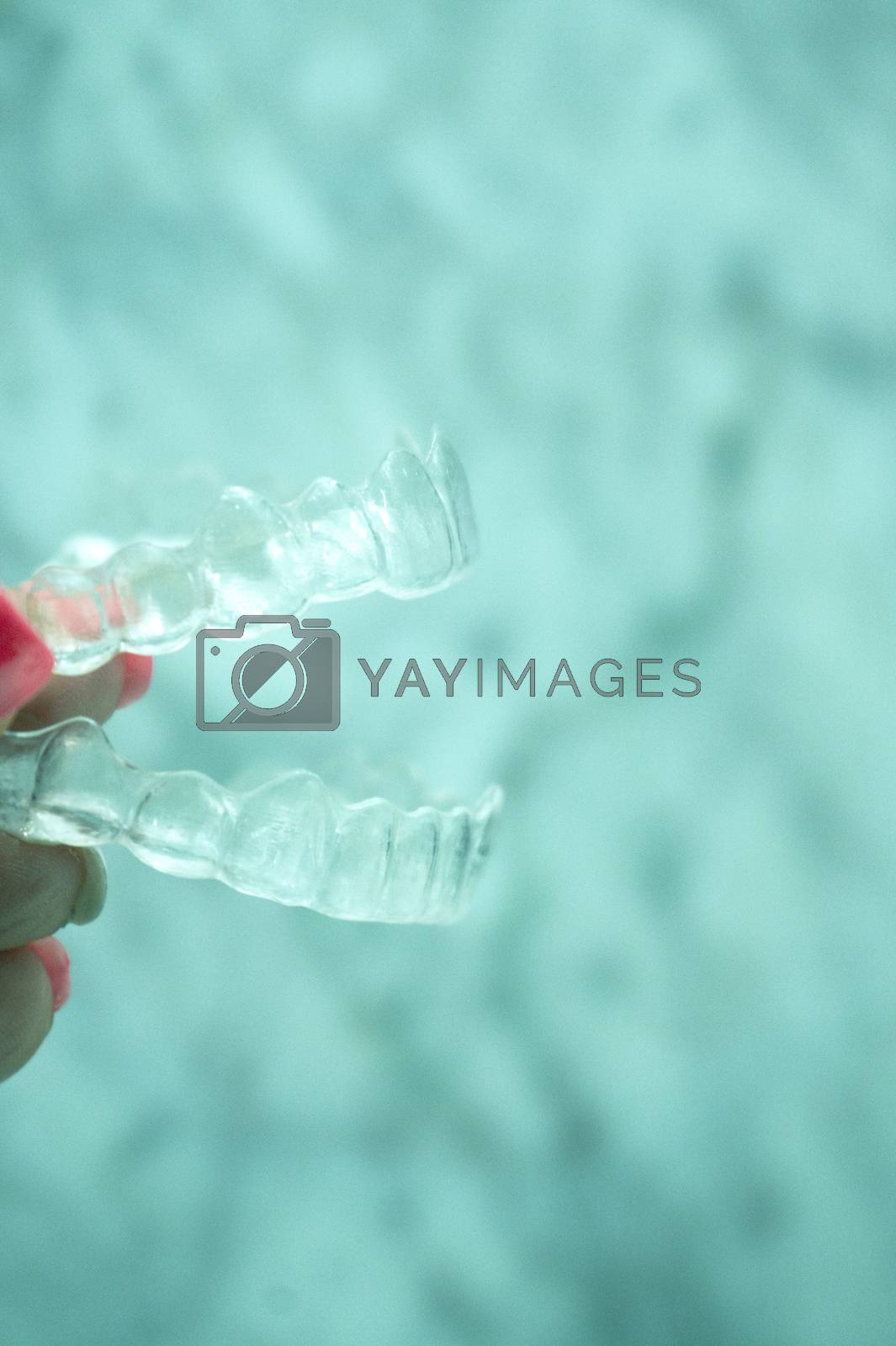 Royalty free image of Invisible dental retainer held by womans hand by GemaIbarra