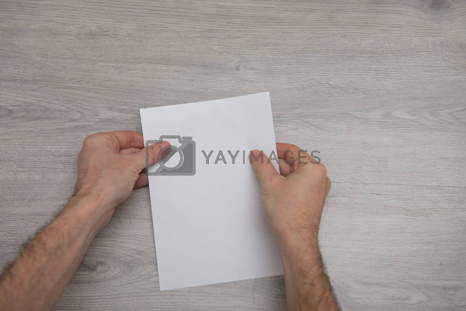 Royalty free image of How to make origami paper airplane step by step photo instruction on wooden table with arms. Step 1 by marynkin