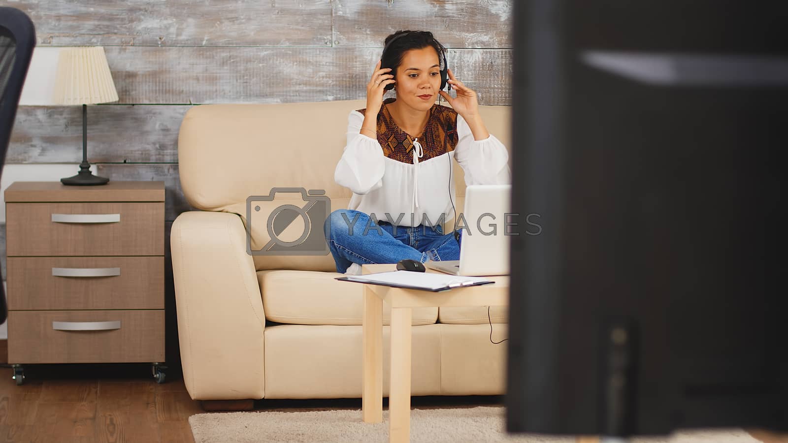Royalty free image of Woman using headphones during a video call by DCStudio