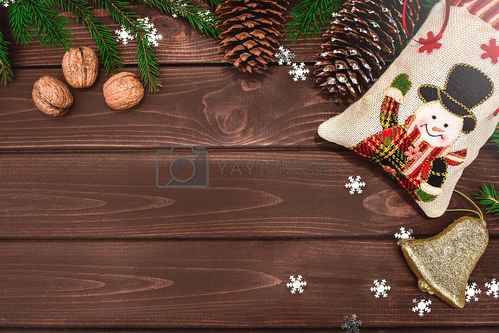 Royalty free image of Christmas background Fir branches, cones and nuts on a wooden table. Space for text. View from above. Christmas atmosphere by Nickstock