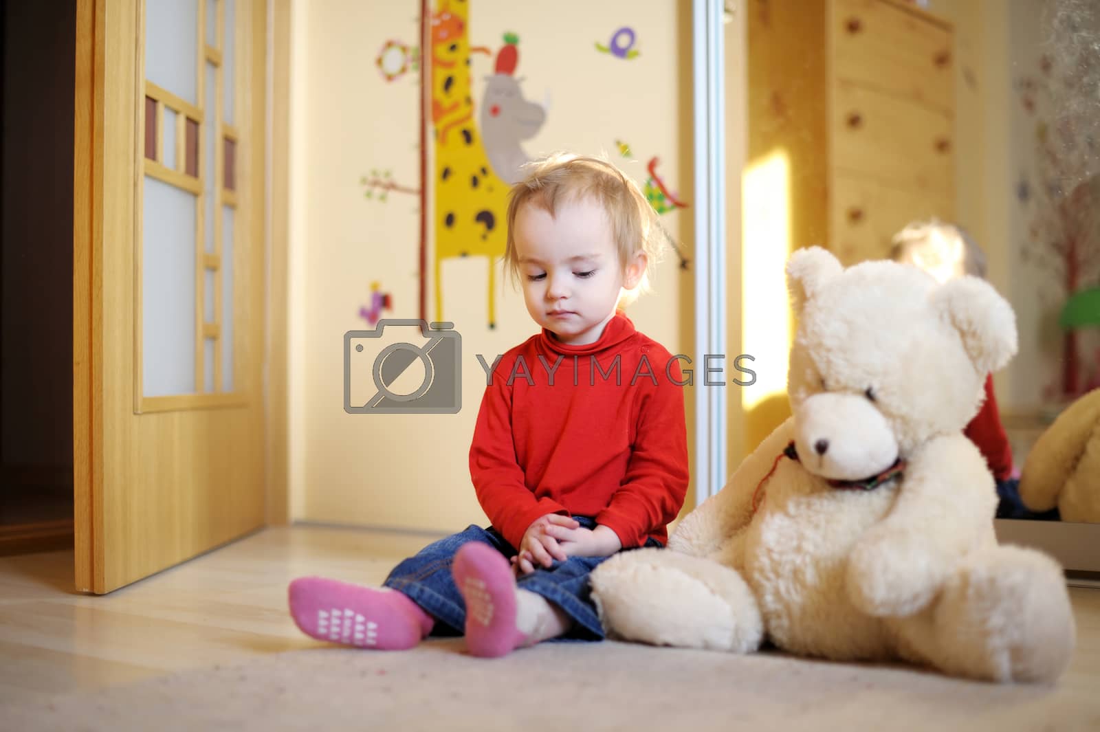 Royalty free image of Little girl sitting on the floor by maximkabb